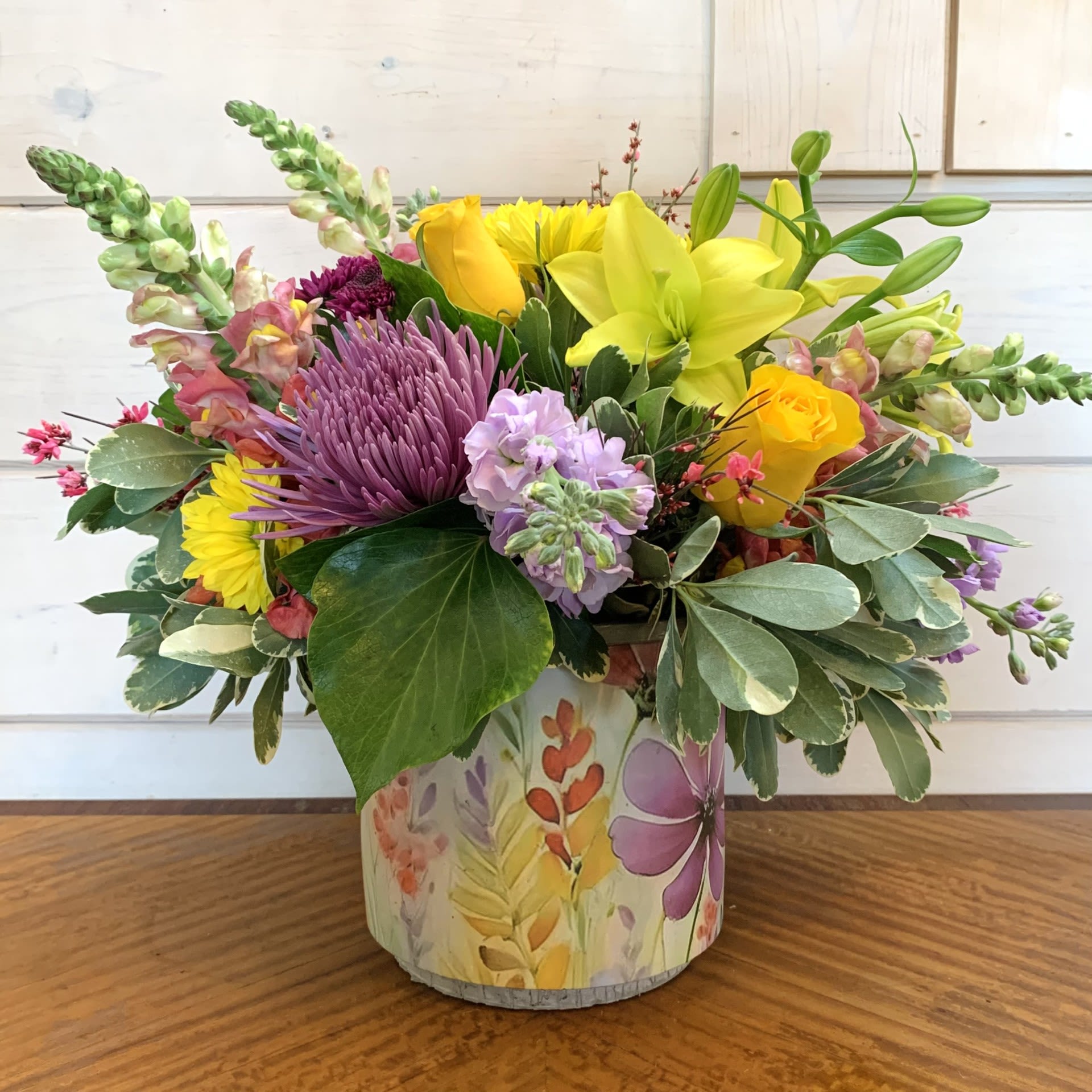 Colorful mixed bouquet in a painted cylindrical container