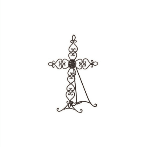 Ornate black metal standing cross with scrollwork on an easel base.