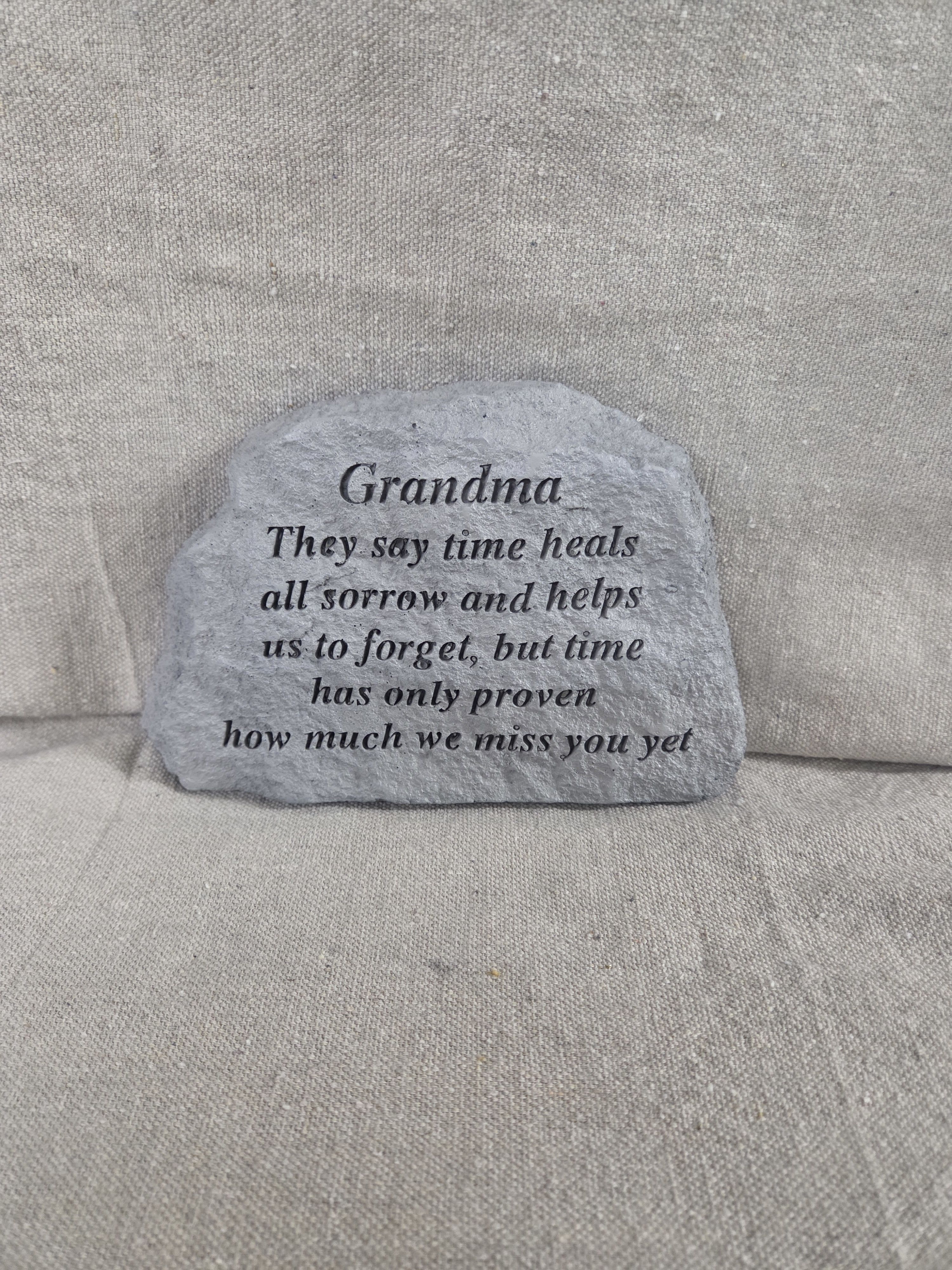 Gray memorial stone for Grandma with engraved verse on a neutral fabric background
