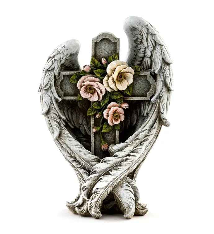 Stone cross framed by angel wings with carved pink and cream flowers in the center.