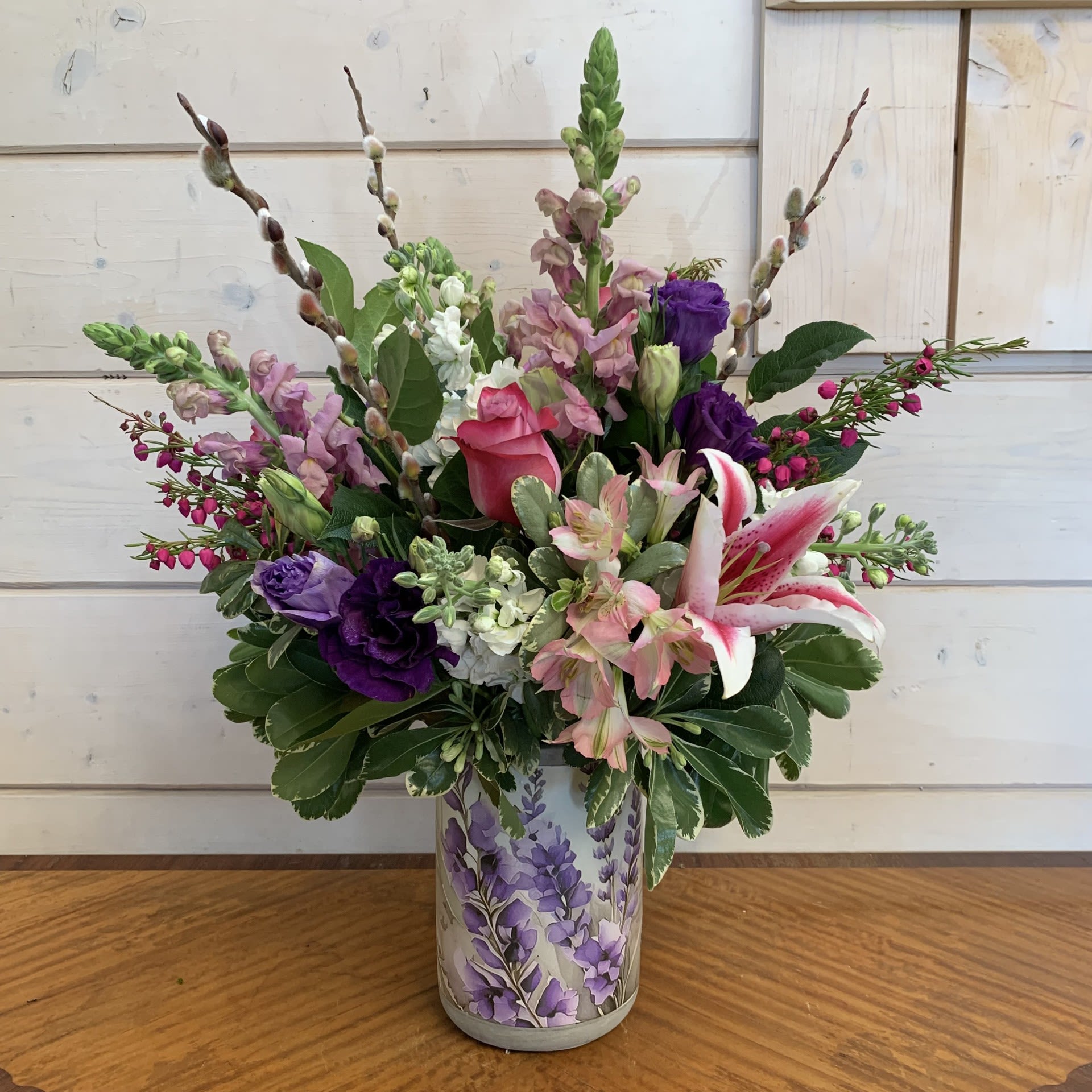 Mixed pink, purple, and white flowers arranged in a decorative vase