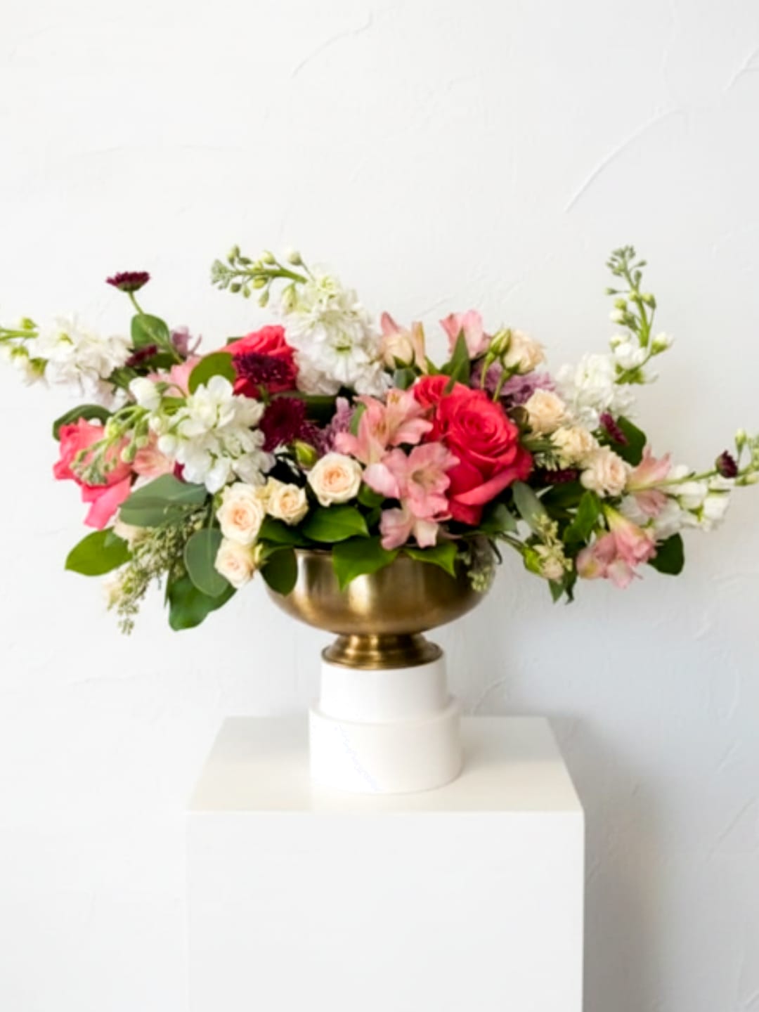 Mixed pink and white flower arrangement in a gold bowl vase