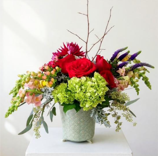 Blooms of Beauty - Celebrate life’s special moments with the Blooms of Beauty, a stunning composition of garden-inspired flowers designed to captivate and delight. This arrangement features a harmonious blend of seasonal flowers such as hybrid roses, green hydrangeas, stock or snapdragons, gerberas or dahlias, berry sprays, sweet William, veronica, and natural foliage like seeded eucalyptus and dusty miller. Seasonal variations ensure each bouquet is uniquely beautiful and fresh. **Features: A lush mix of premium blooms and greenery, thoughtfully arranged to create a timeless, garden-style design. **Seasonal Adaptability: Flowers like gerberas may be substituted with seasonal favorites such as peonies, lilies, or dahlias, ensuring the arrangement is always vibrant and fresh. **Presentation: Delivered in a glazed seasonal inspired ceramic cache-pot, this arrangement adds an elegant touch to any space. Perfect for anniversaries, birthdays, or as a “just because” gift, the Blooms of Beauty is a heartfelt way to share joy and appreciation. Hand-delivered for a personal touch, this arrangement is sure to leave a lasting impression. Order now to send a gift that blooms with love and charm!