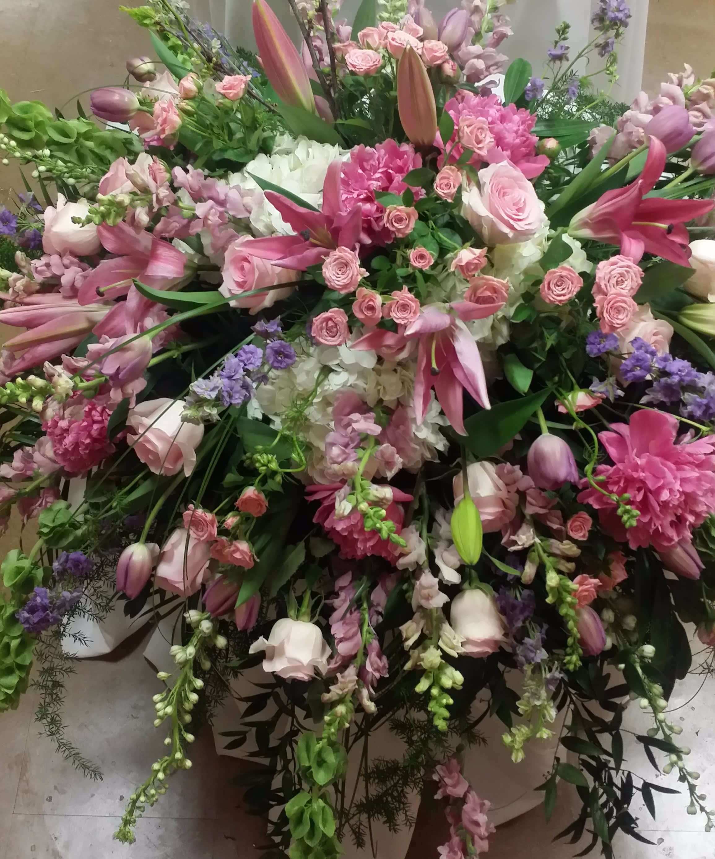 Large pink and white floral arrangement with lilies, roses, and mixed blooms