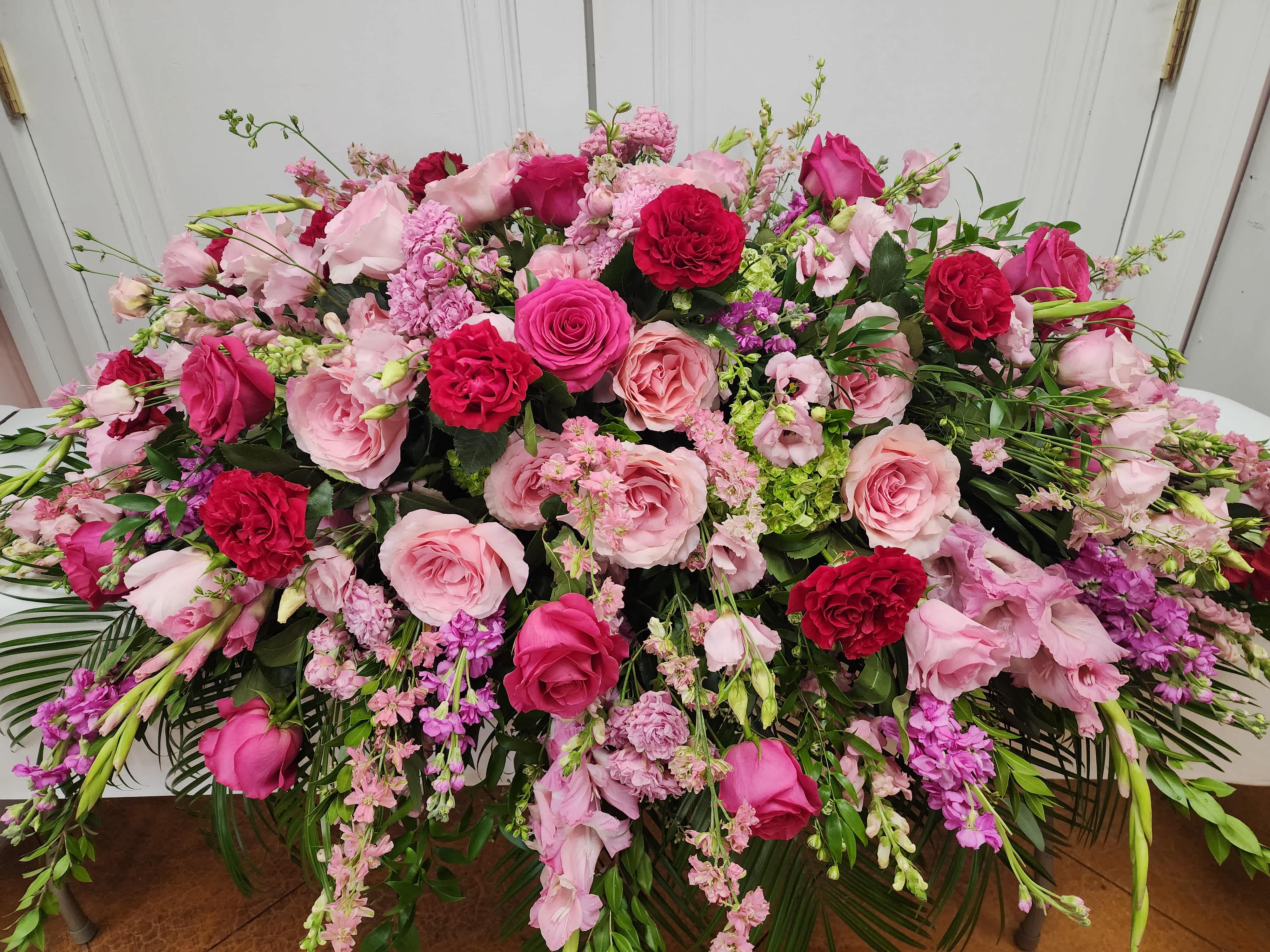 Large pink and red floral arrangement with roses and mixed blooms