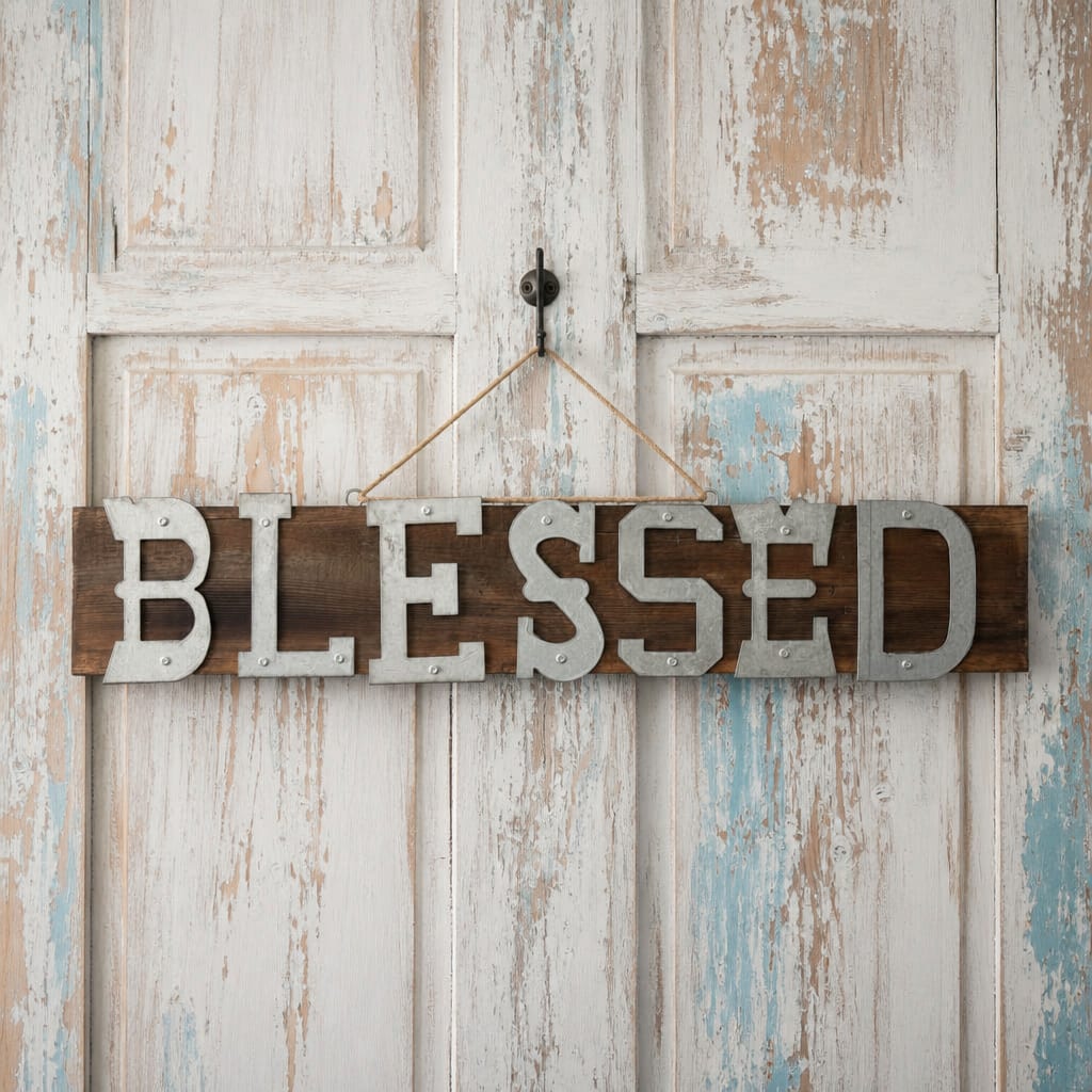 Wooden sign reading "BLESSED" hanging on a distressed white door