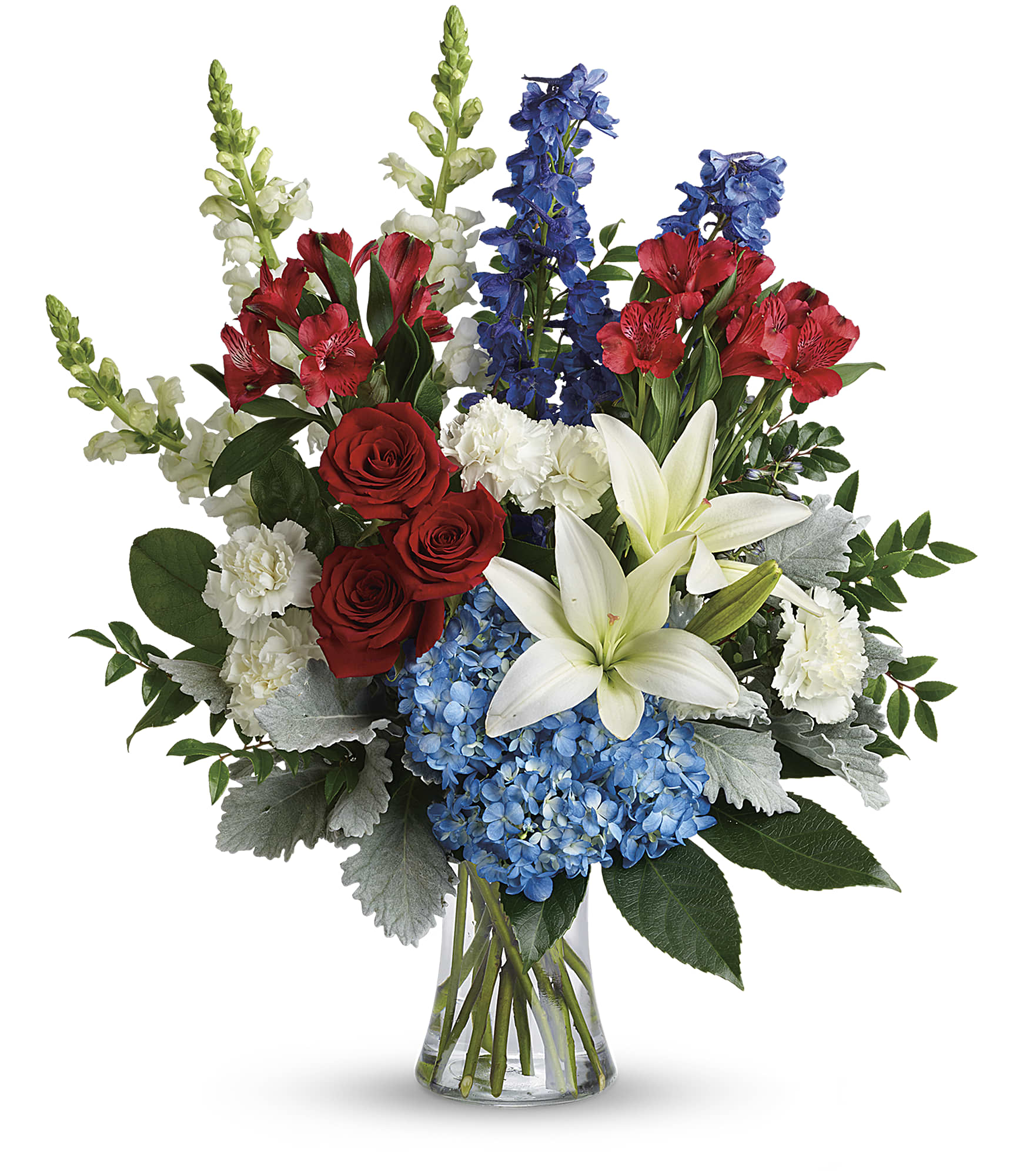 Mixed bouquet with red roses, white lilies, blue hydrangeas, and red and blue flowers in a glass vase