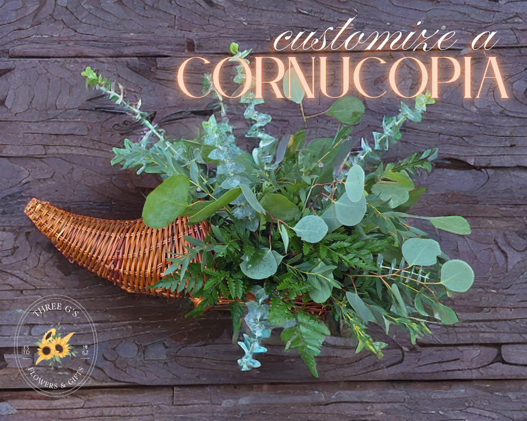 Wicker cornucopia filled with assorted greenery on a wood background