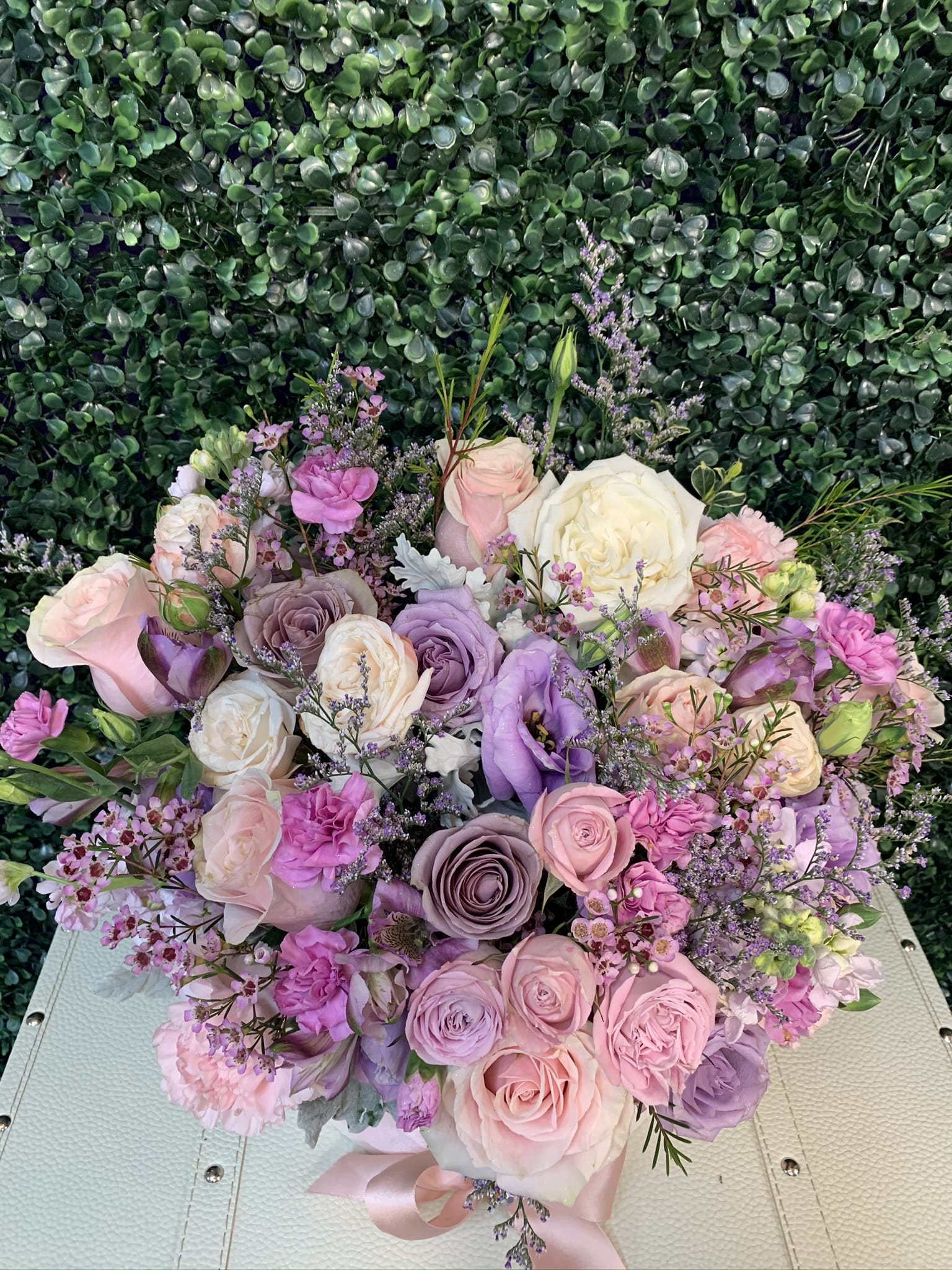 Pastel bouquet of roses and lisianthus with small purple filler flowers
