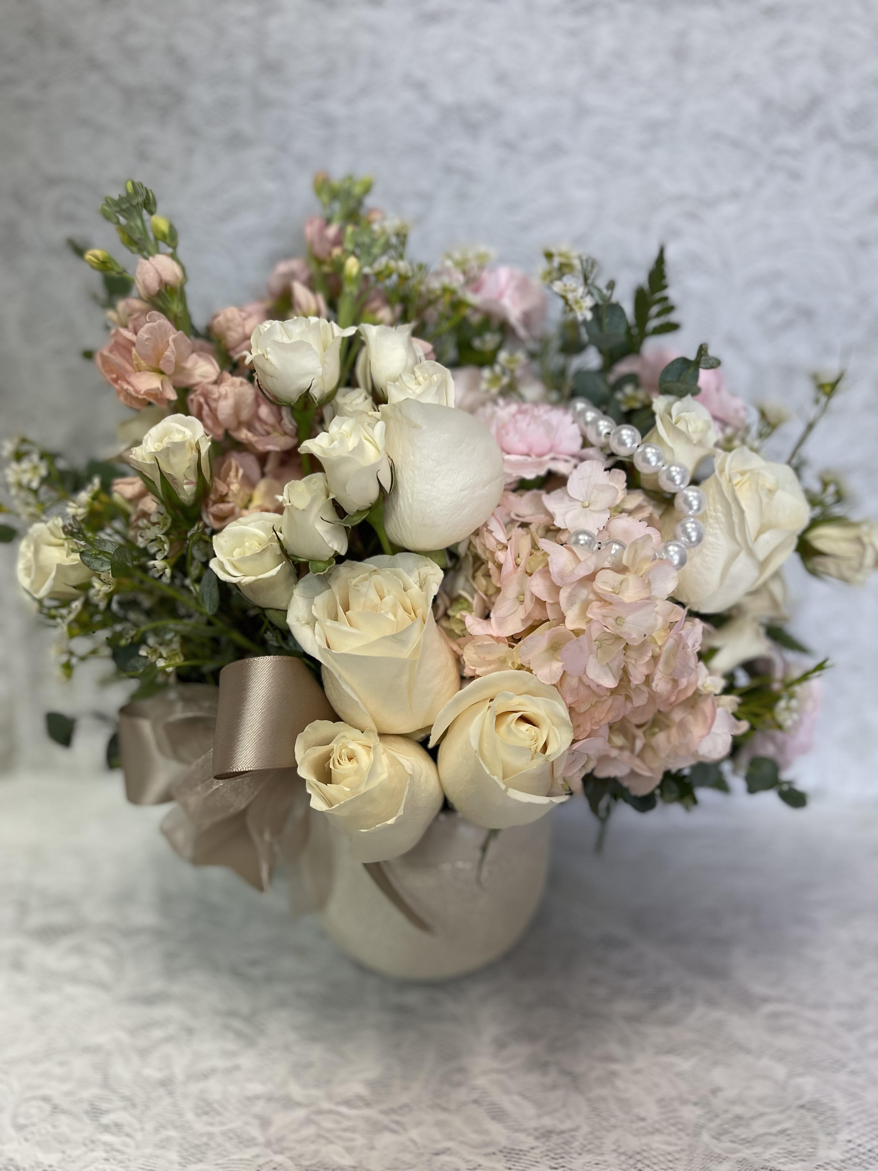 Cream roses and pink hydrangeas in a ribboned vase
