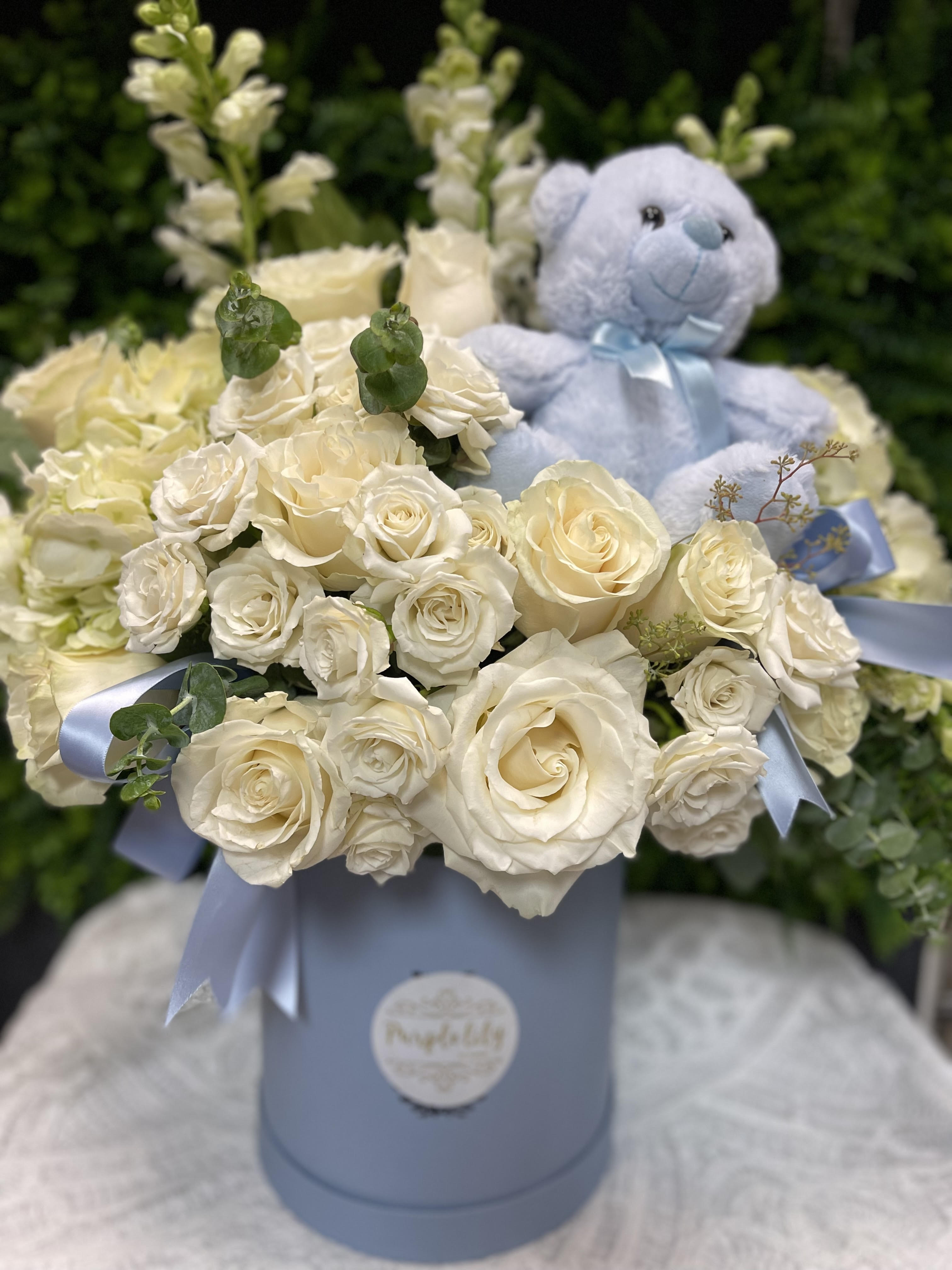 Cream rose bouquet with a blue teddy bear in a pastel box