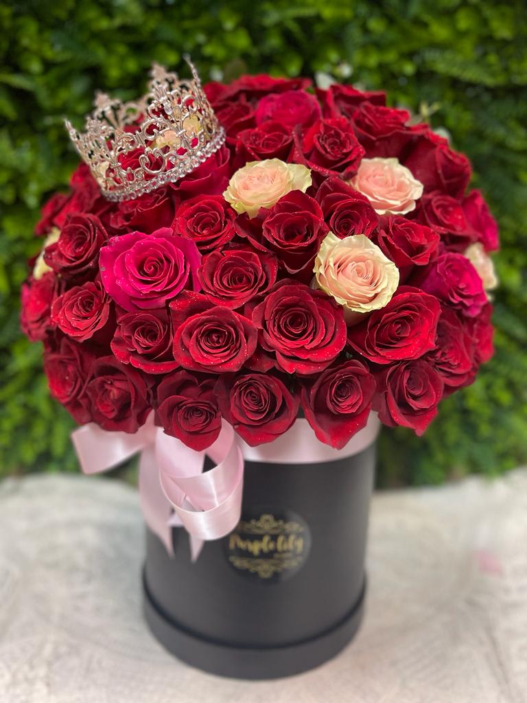 Enchanted Field PLA122 - Red and pink roses delicately arranged and finished up with a lovely, shiny crown to enchant your loved one! Including the crown.