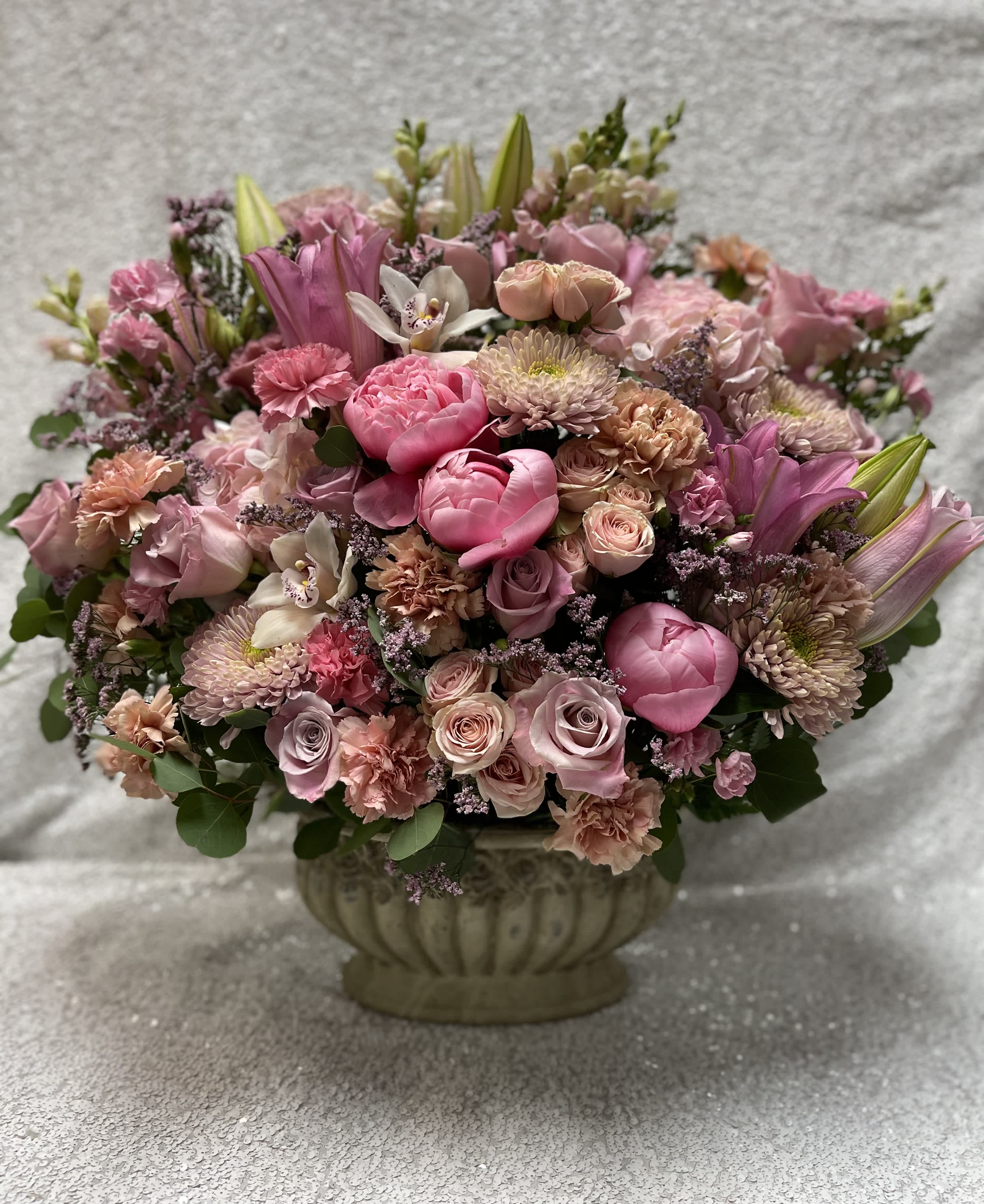Pink mixed flower arrangement in a decorative urn vase