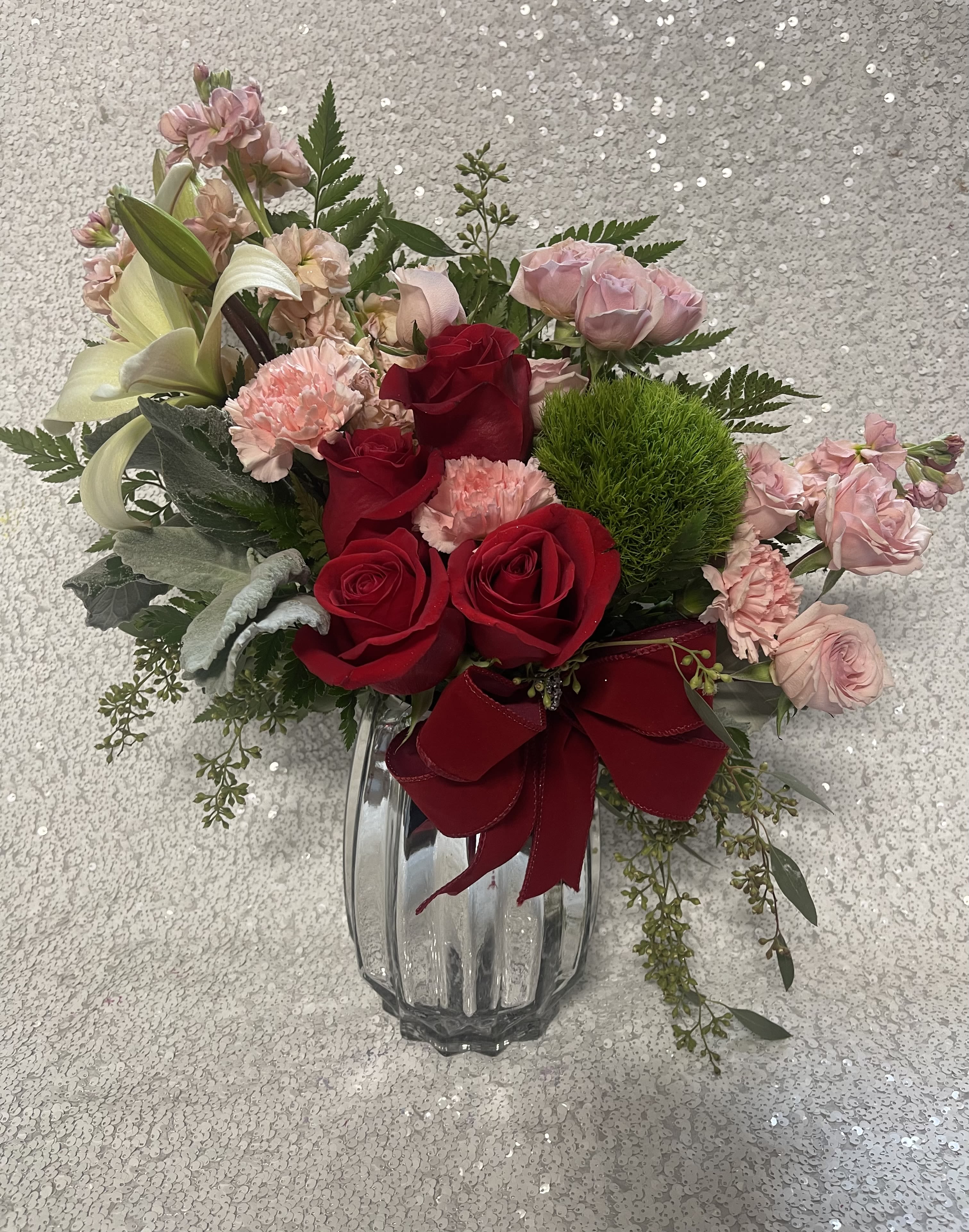 Bouquet of red and pink roses with lilies in a glass vase