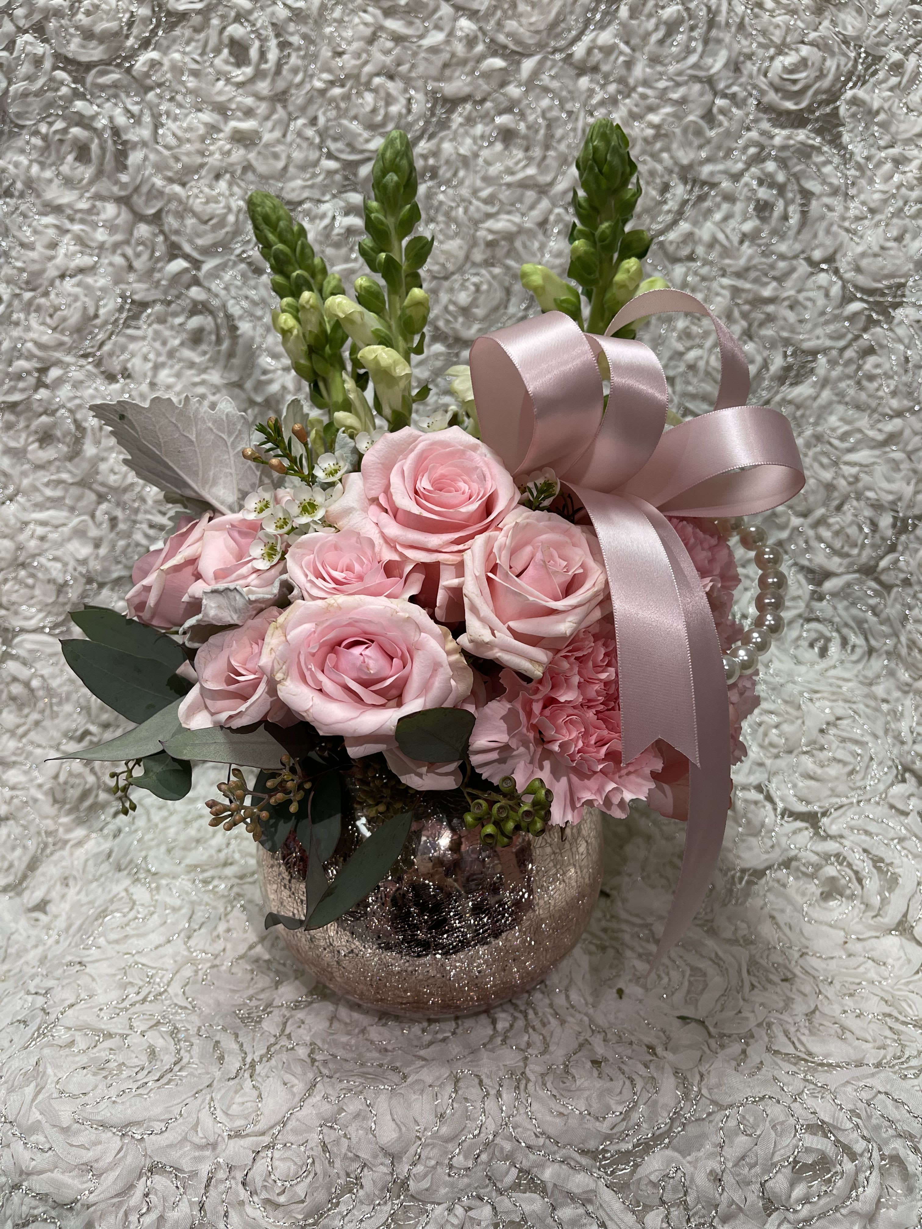 Pink rose arrangement in a glittery vase with a satin ribbon