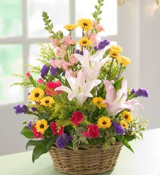 Mixed flower arrangement in a wicker basket with lilies and daisies