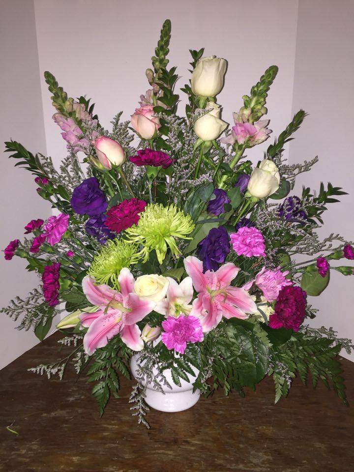 Large mixed bouquet in a white vase with pink lilies and roses