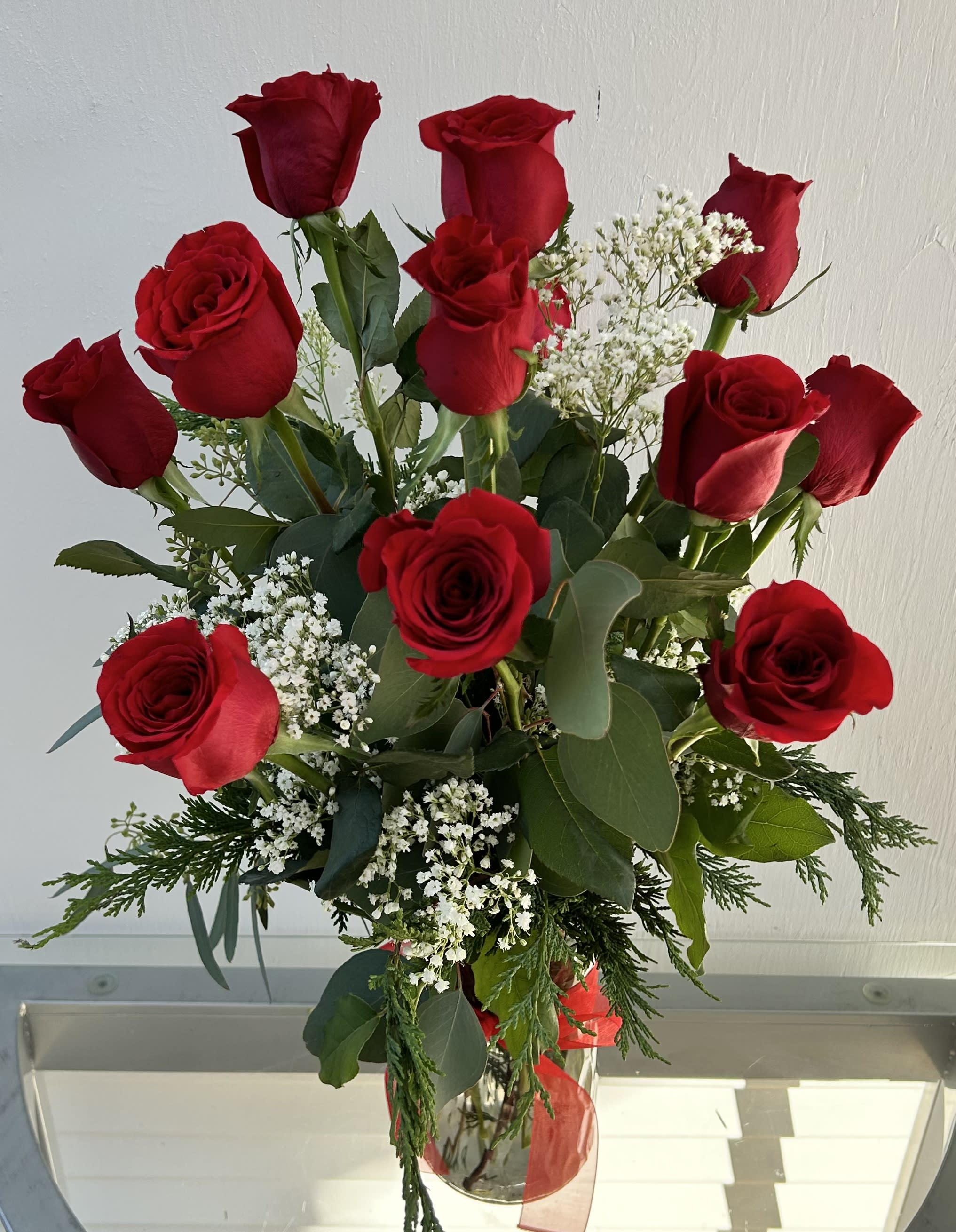 Bouquet of red roses with white filler flowers in a glass vase