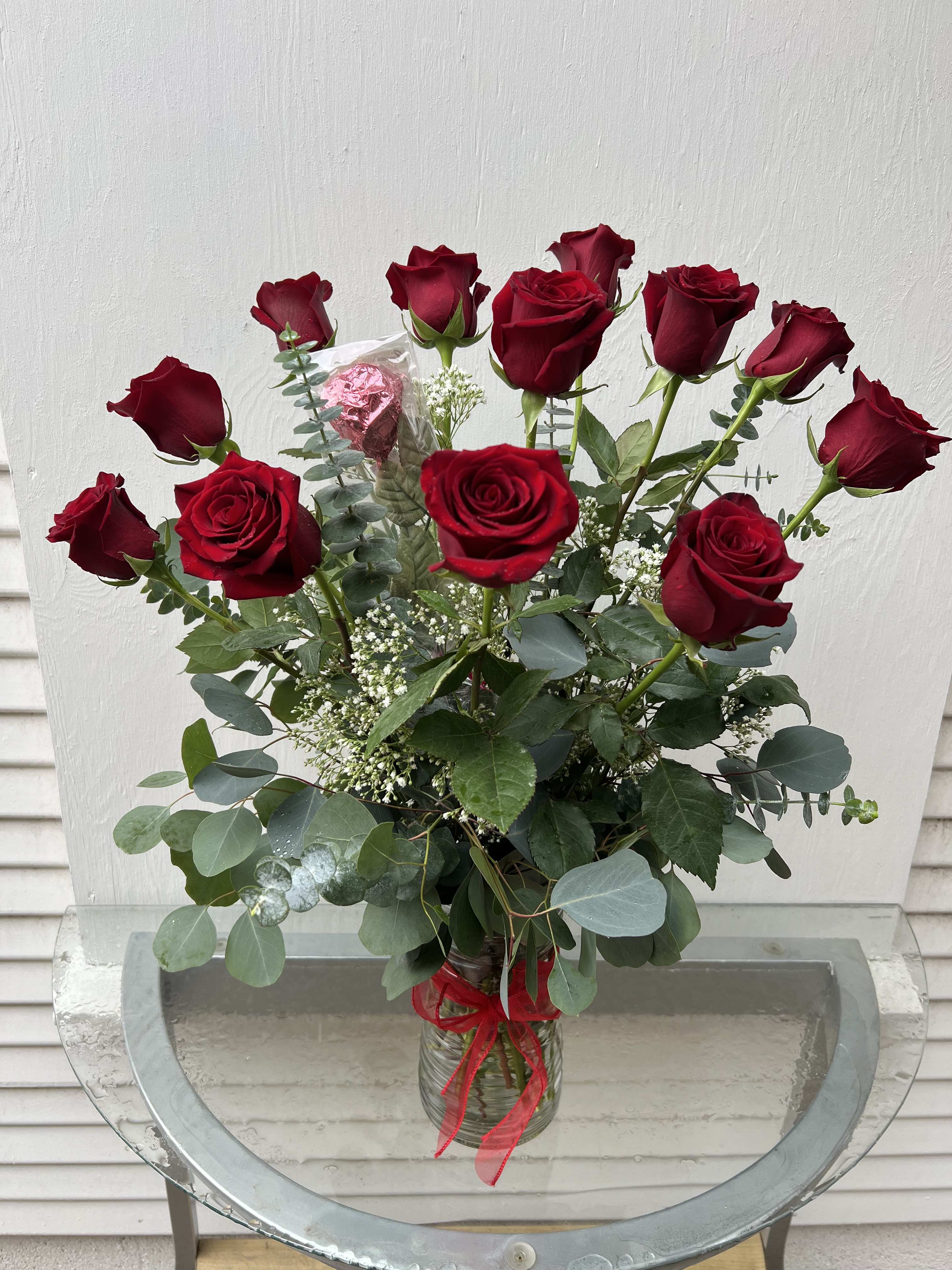 Bouquet of red roses in a glass vase with a red ribbon