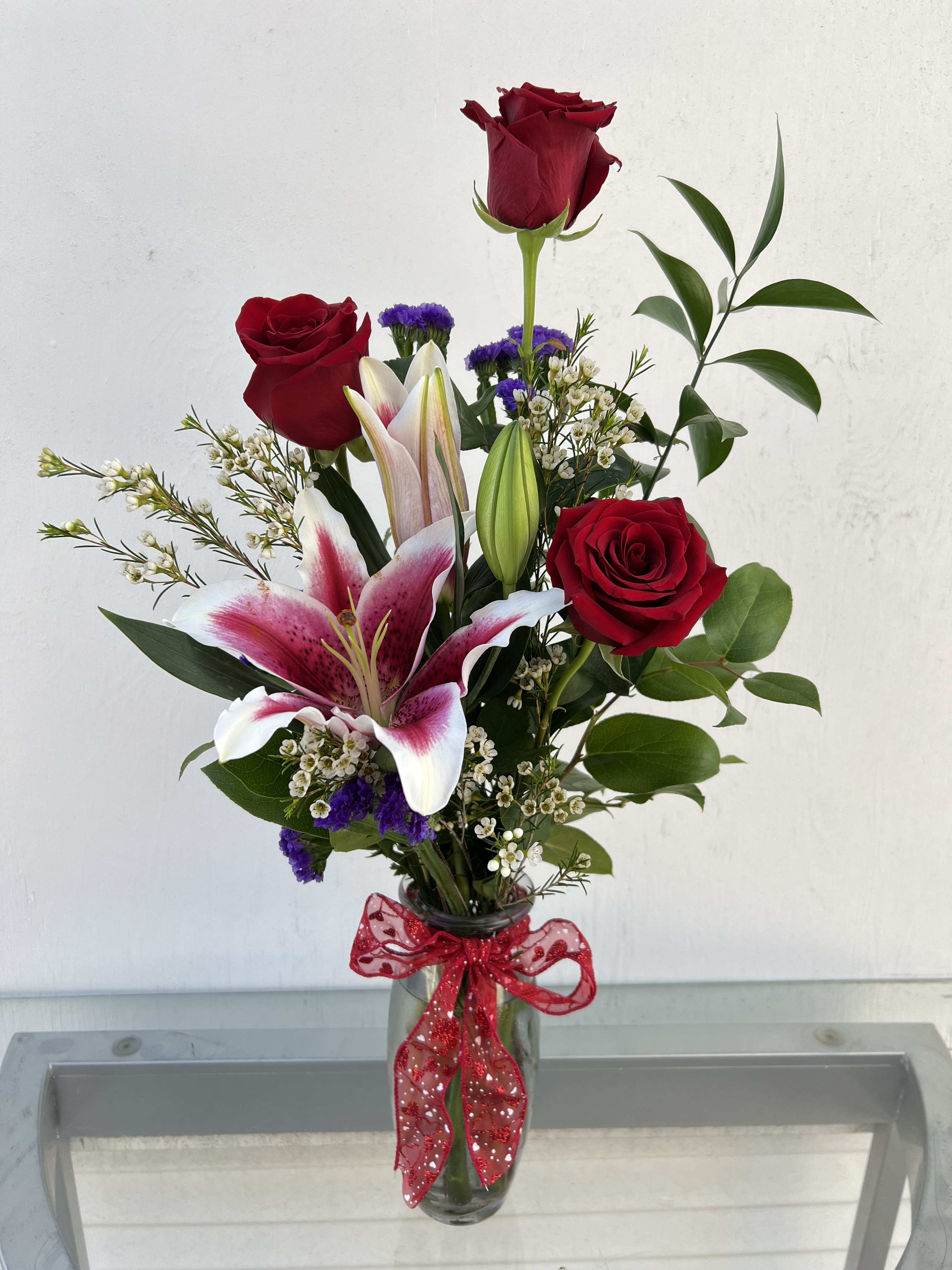 Be Mine - Red Roses and a Lily. Colors may vary on lilies, roses.