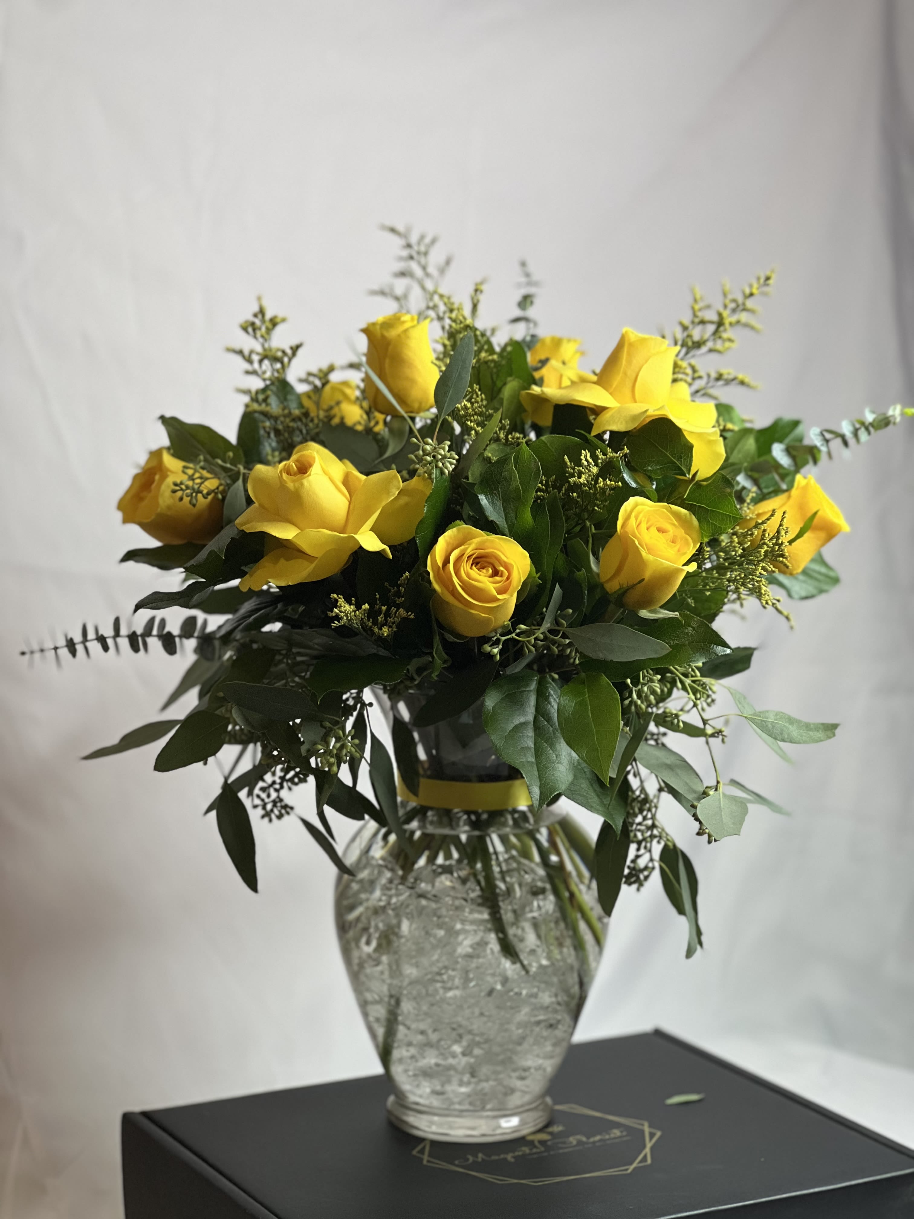 BRIGHTON VASE YELLOW  - This arrangement is made with 12 premium Ecuadorian yellow roses and mix greeneries in a glass 10” vase. Perfect to say get well, happy birthday or just because.