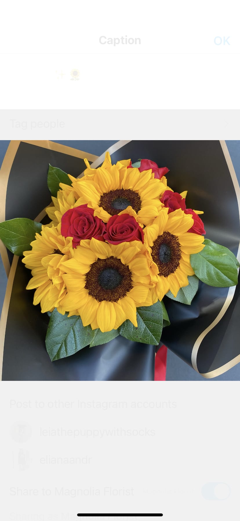 Bouquet of yellow sunflowers and red roses wrapped in black paper