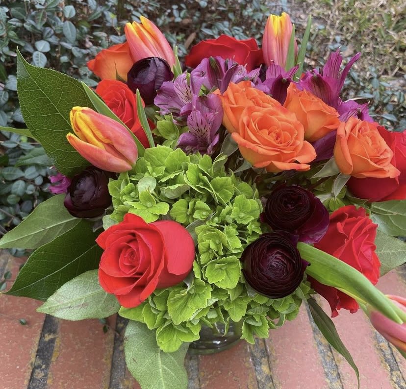 Bouquet of orange and red roses with tulips and purple flowers