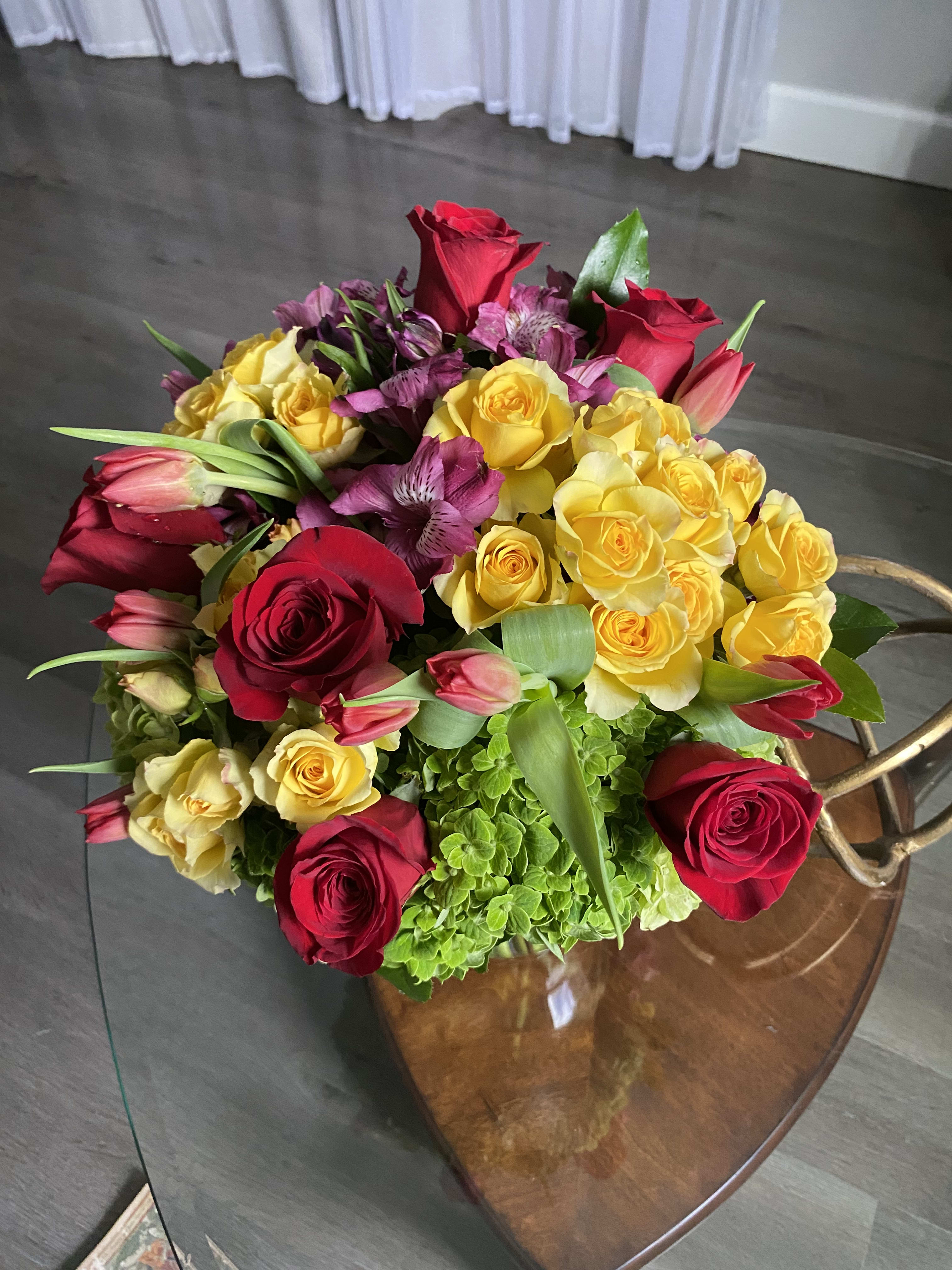 Bouquet of red and yellow roses with pink tulips and purple flowers