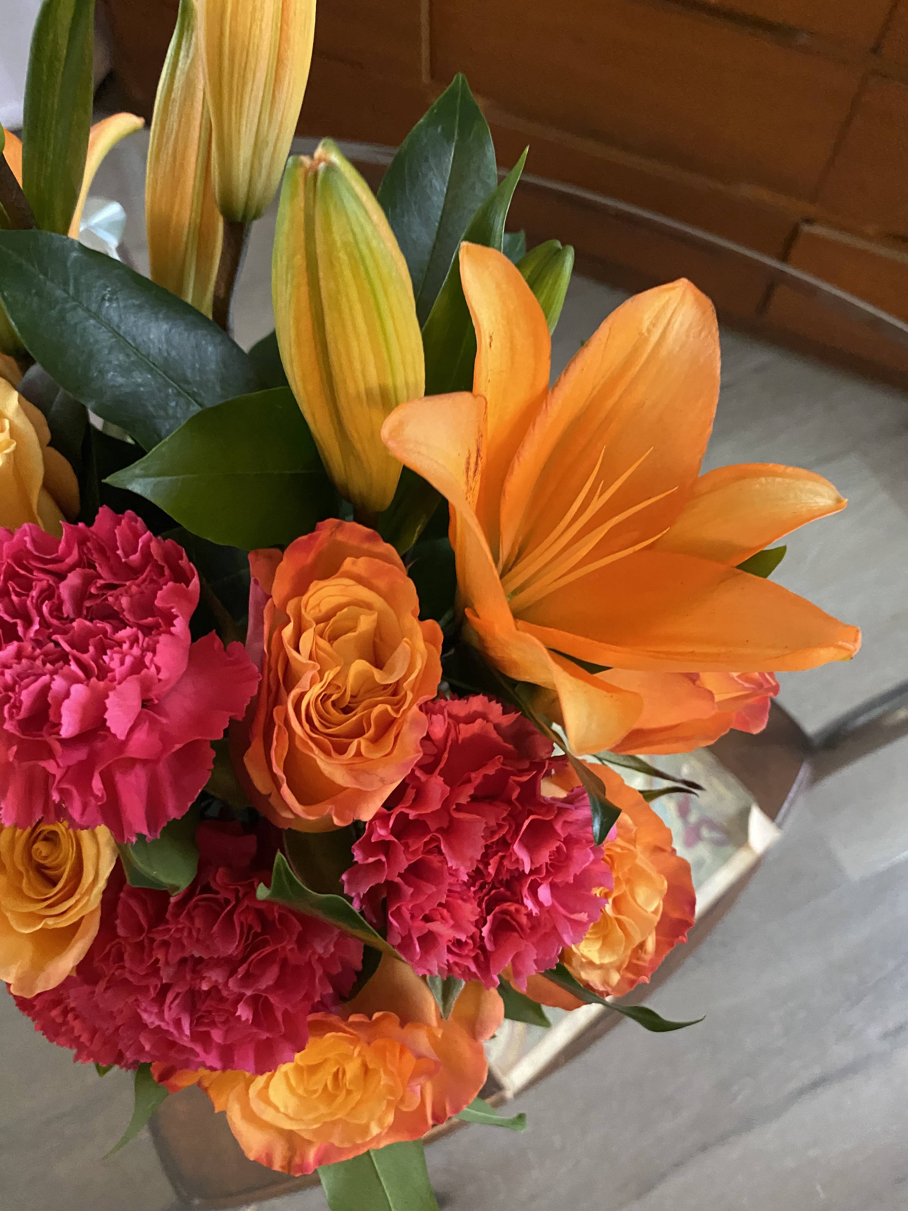 Bouquet of orange lilies and pink carnations with orange roses