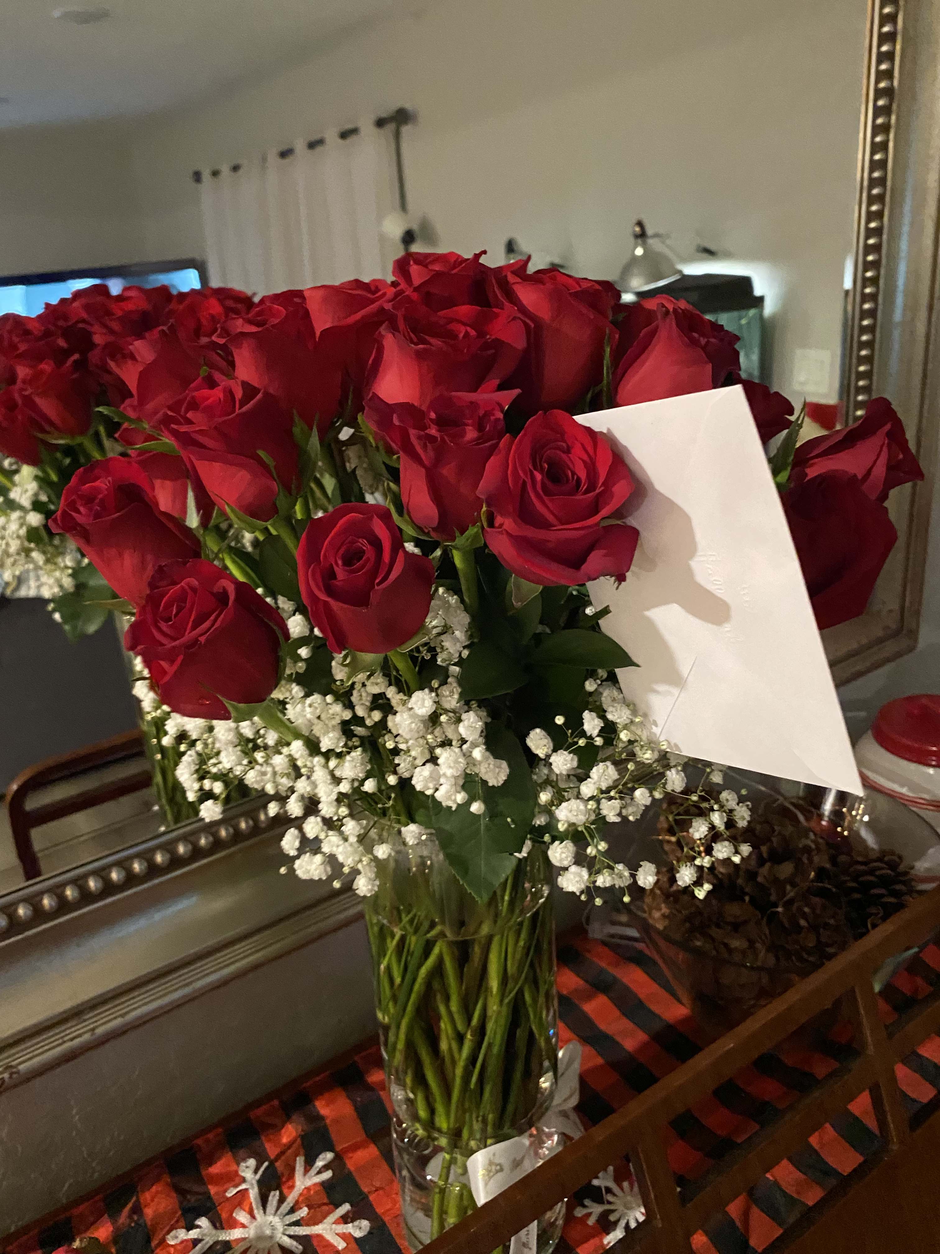 Bouquet of red roses with baby's breath in a clear glass vase