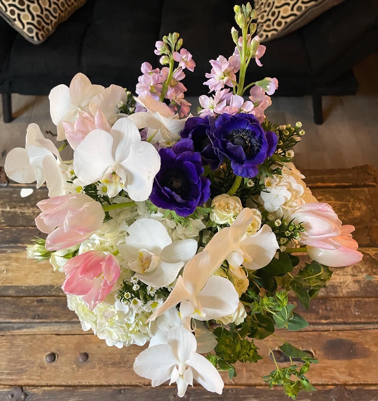 Bouquet of white orchids, pink tulips, and purple anemones