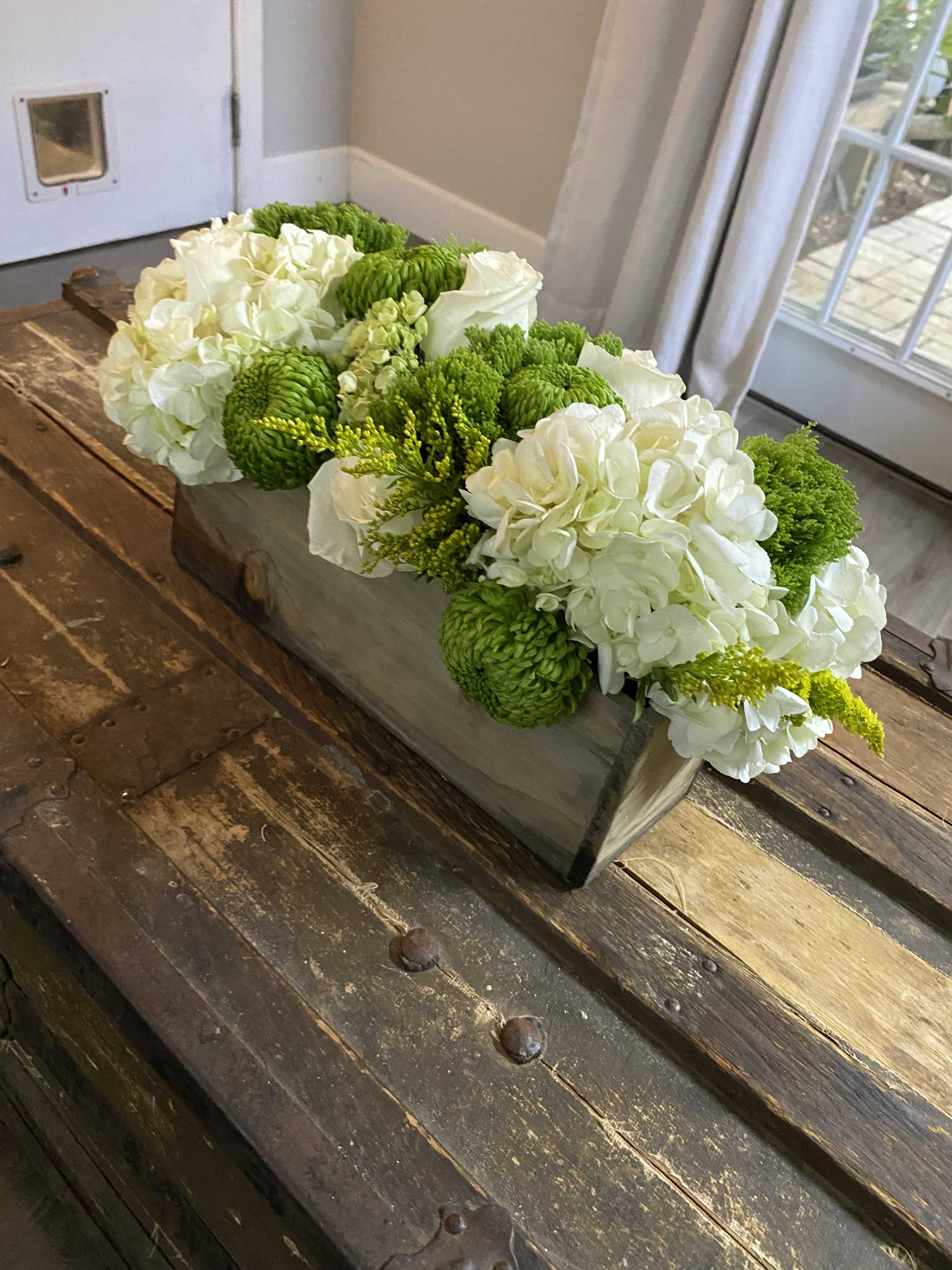White and green floral arrangement in a rectangular wooden box