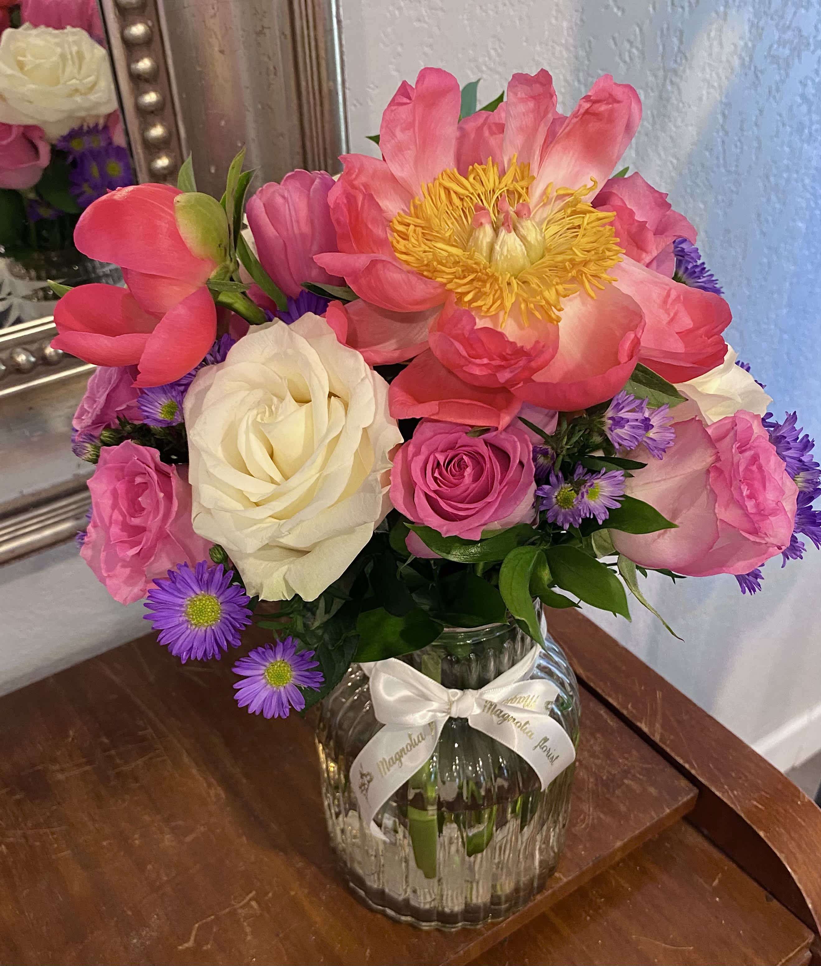 Pink and white roses with a large pink peony in a glass vase