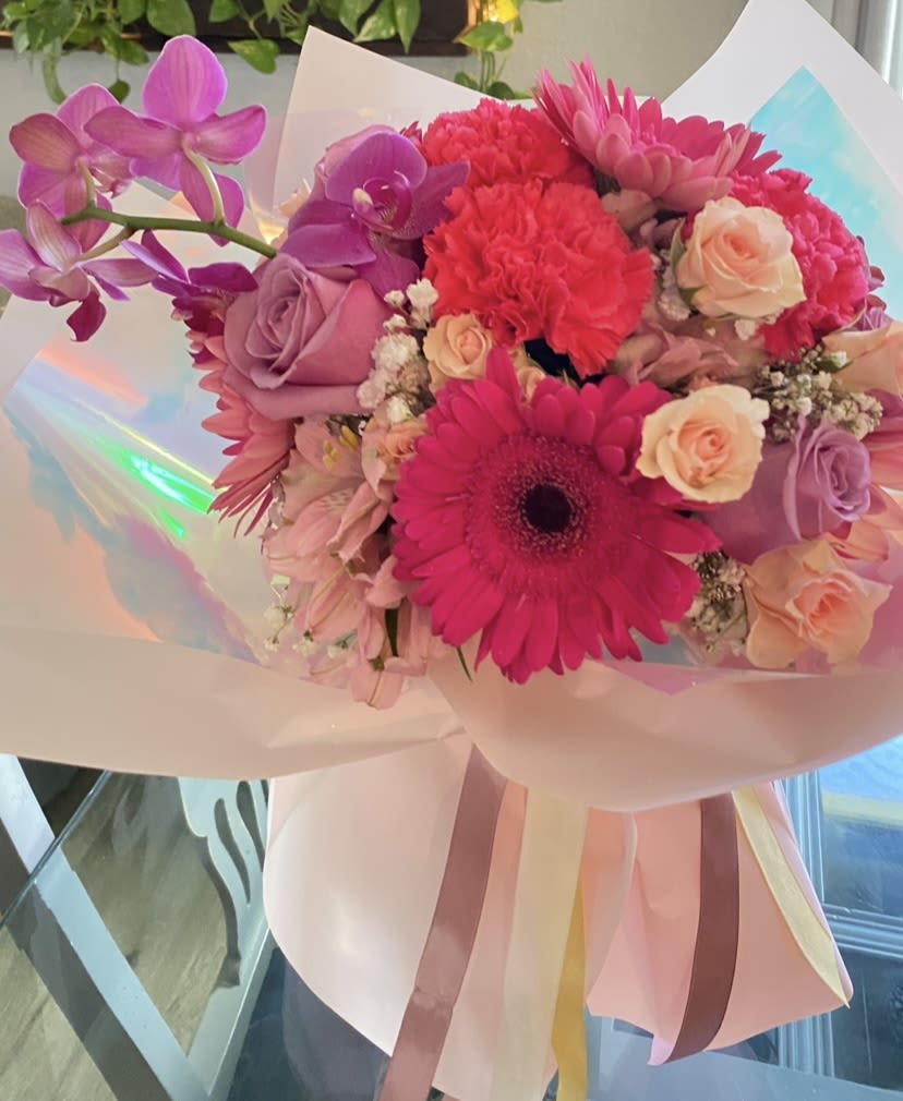 Pink and purple bouquet with gerbera daisies, roses, and orchids