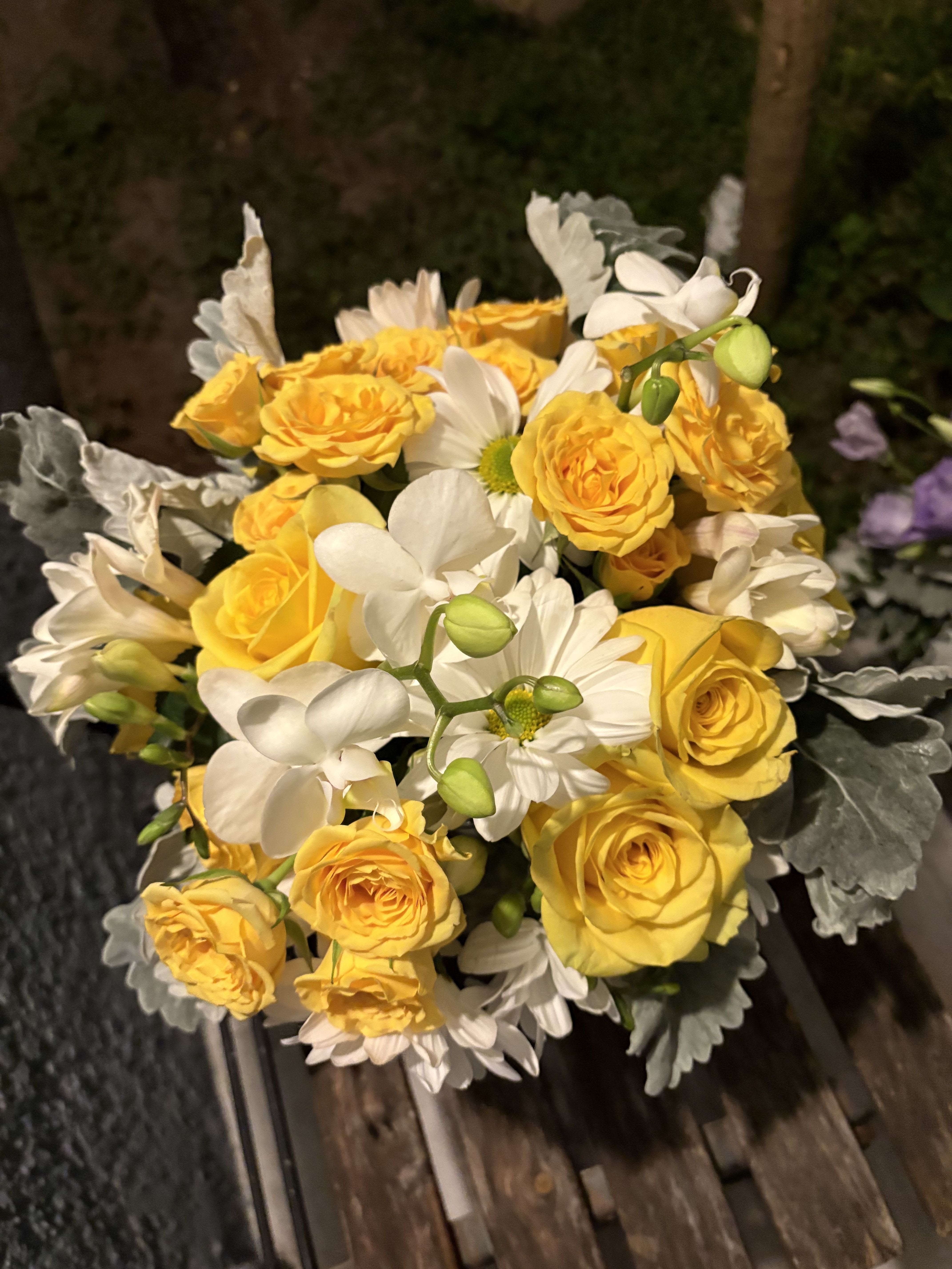 Bouquet of yellow roses and white daisies with silvery foliage