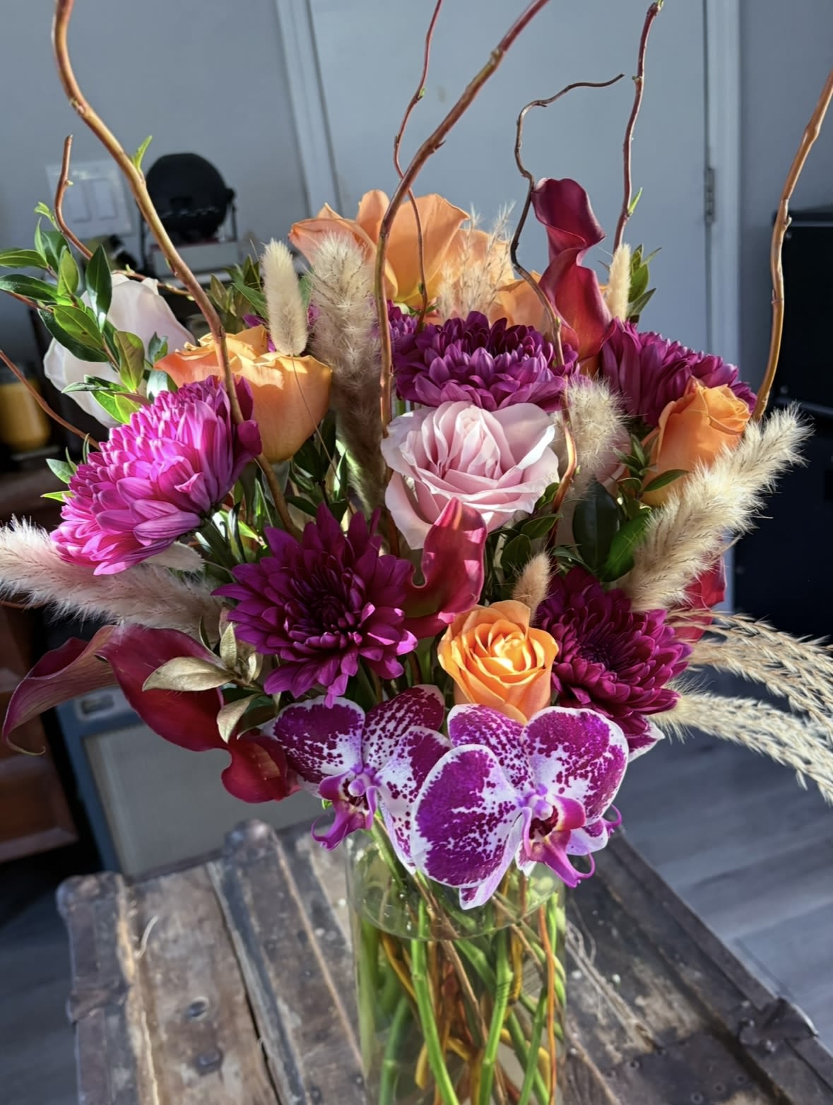 Bouquet of purple, orange, and pink flowers in a glass vase