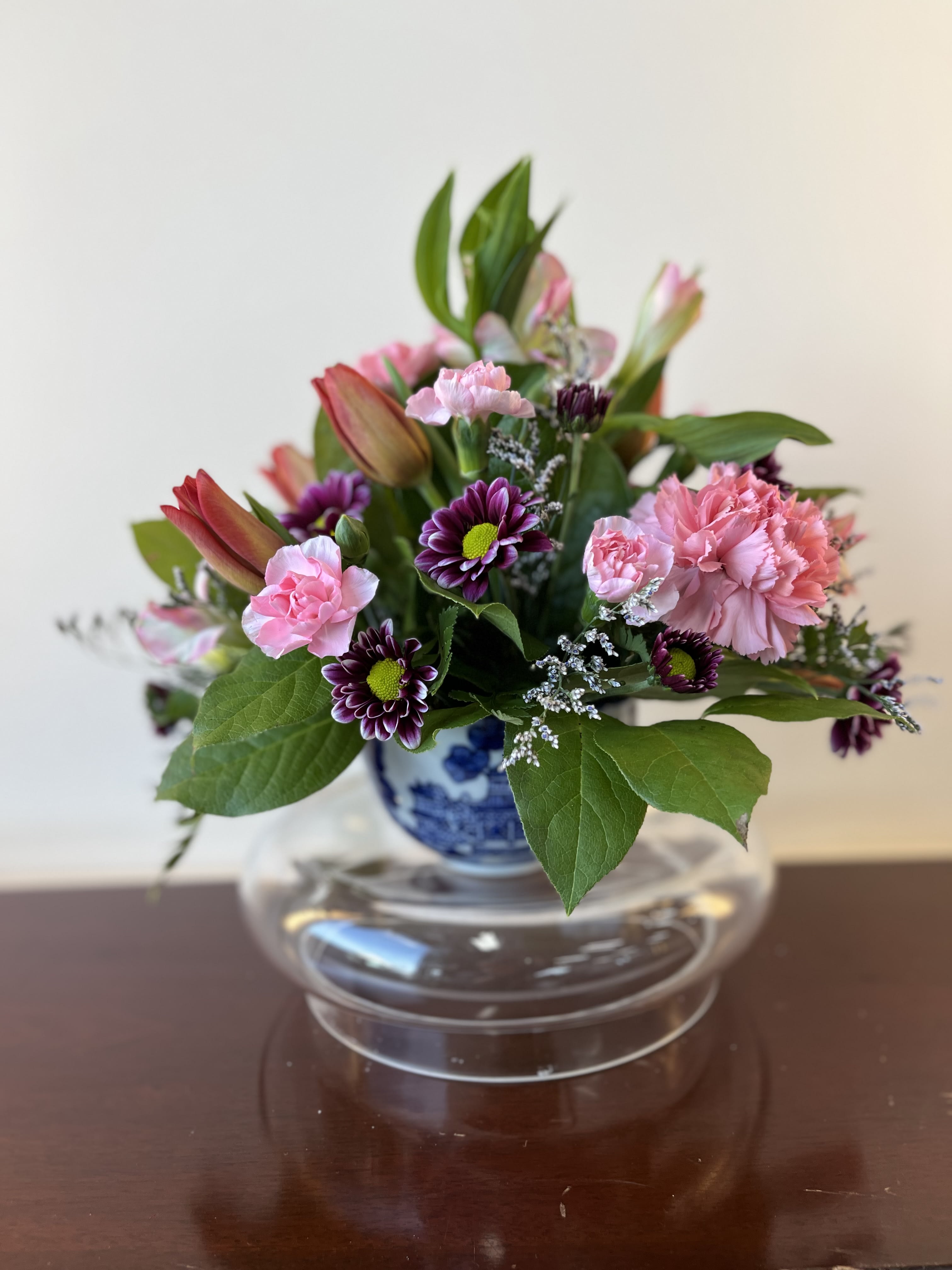 Pink and purple mixed bouquet in a blue-and-white vase