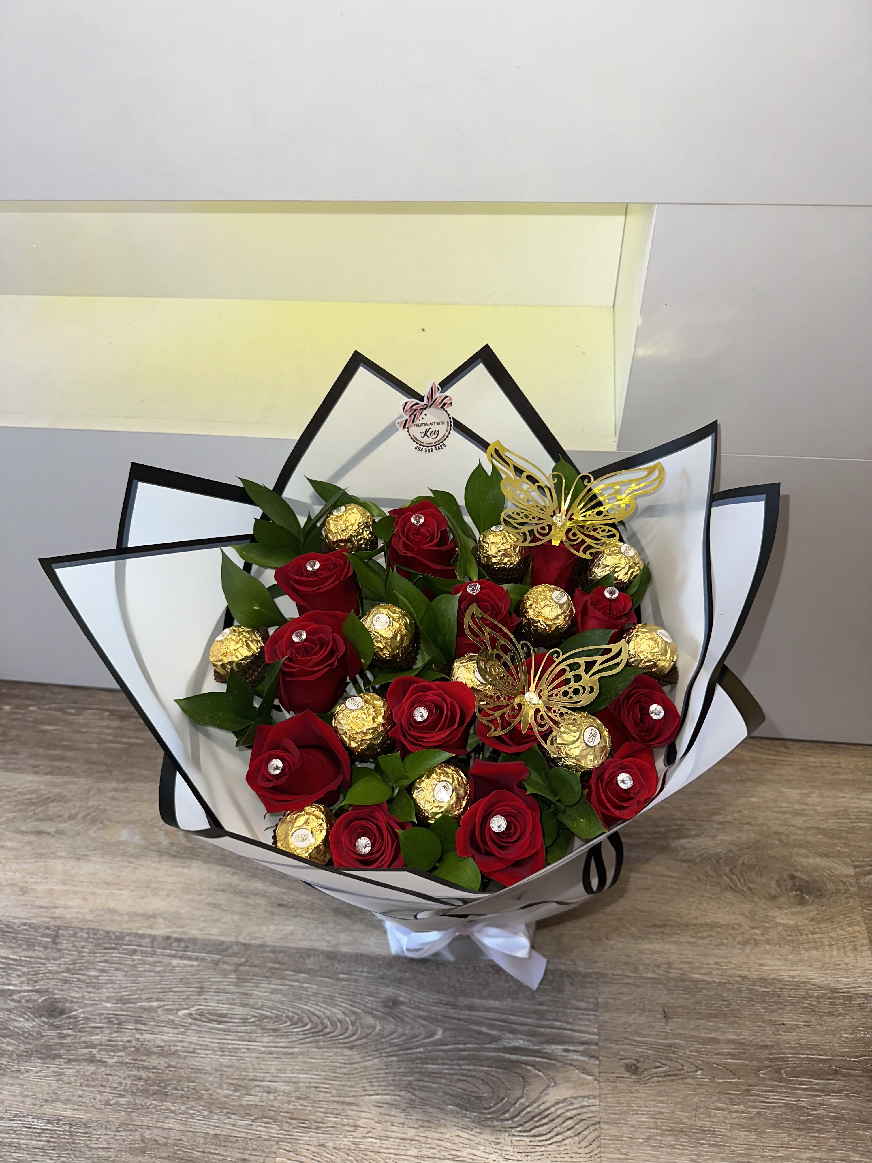 Bouquet of red roses and gold-wrapped chocolates with butterfly picks