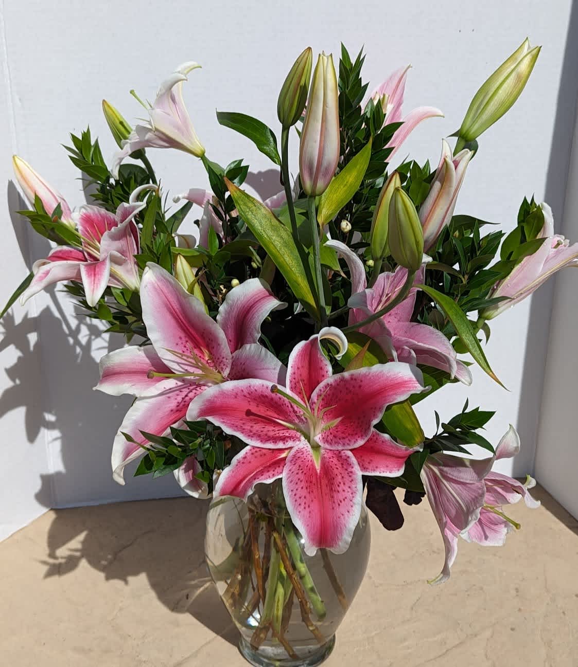 Pink stargazer lilies arranged in a clear glass vase