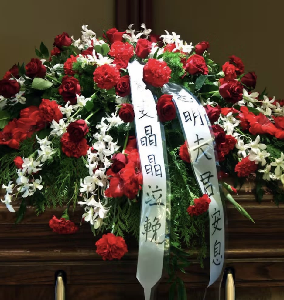 Large red and white floral funeral spray with ribbon streamers