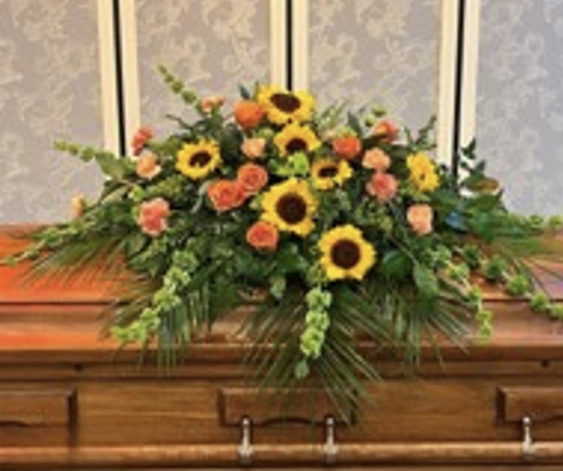 Casket spray with sunflowers and orange roses