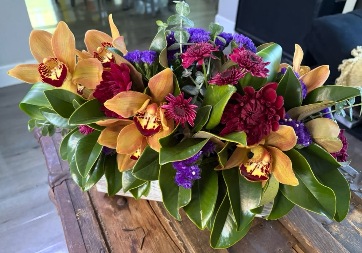 Tropical bouquet with orange orchids and magenta flowers