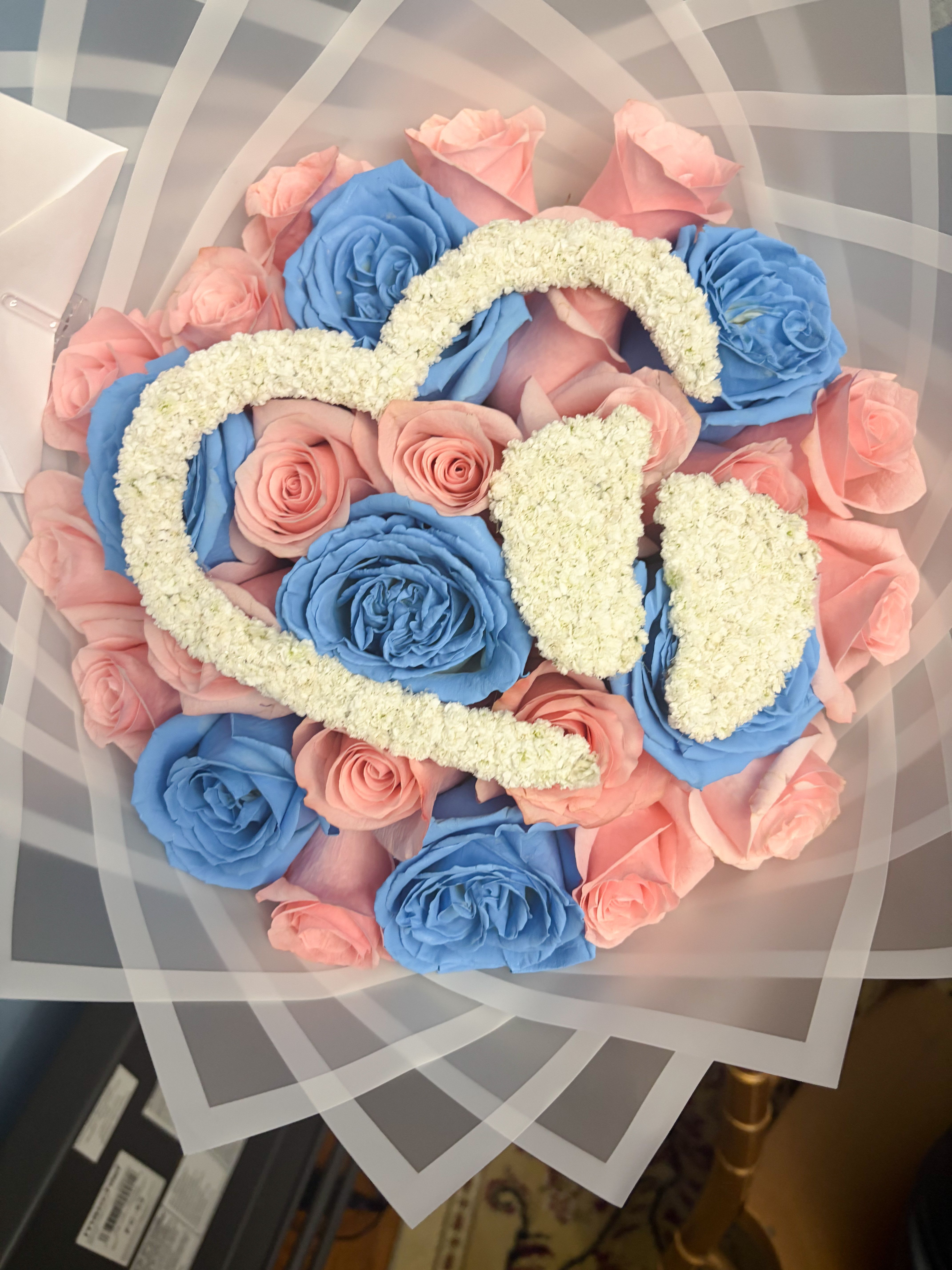 Gender reveal bouquet  - A beautiful bouquet perfect for gender reveals.This bouquet comes with a total of 25 beautiful pink and blue roses, and heart an baby feet topper made with baby's breath.