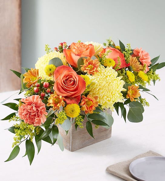 Orange roses and yellow chrysanthemums in a wooden box