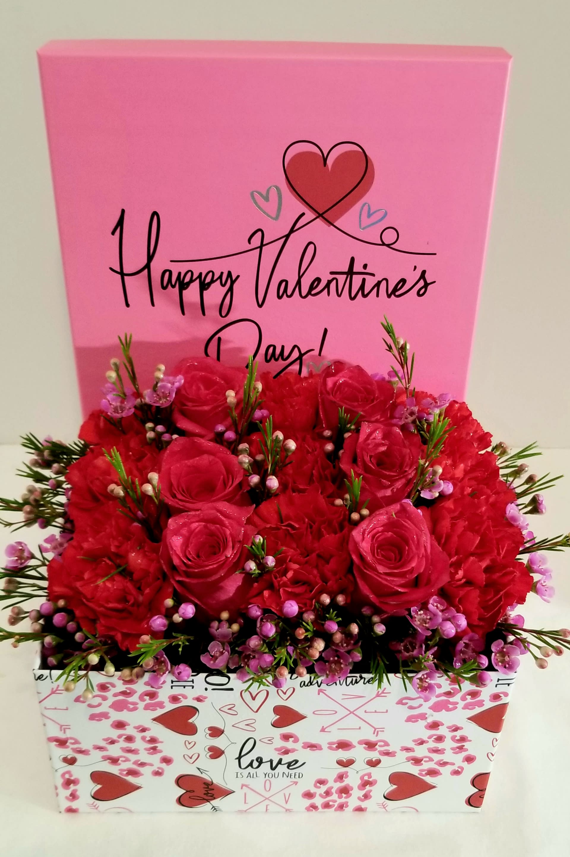 Pink Valentine’s Day gift box with red roses and a heart design