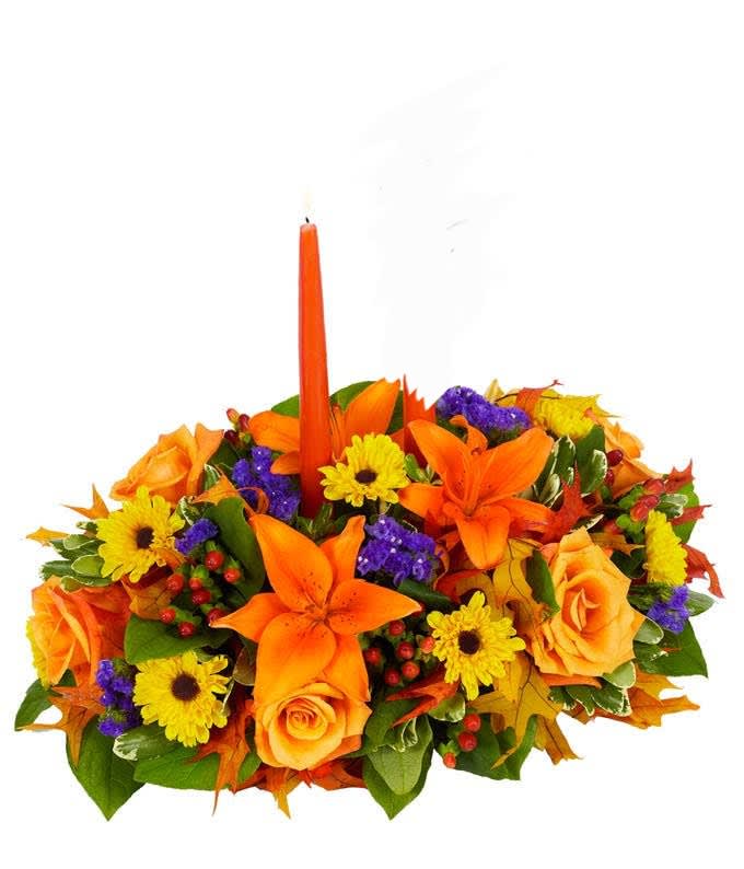 Orange and yellow floral centerpiece with a tall orange candle