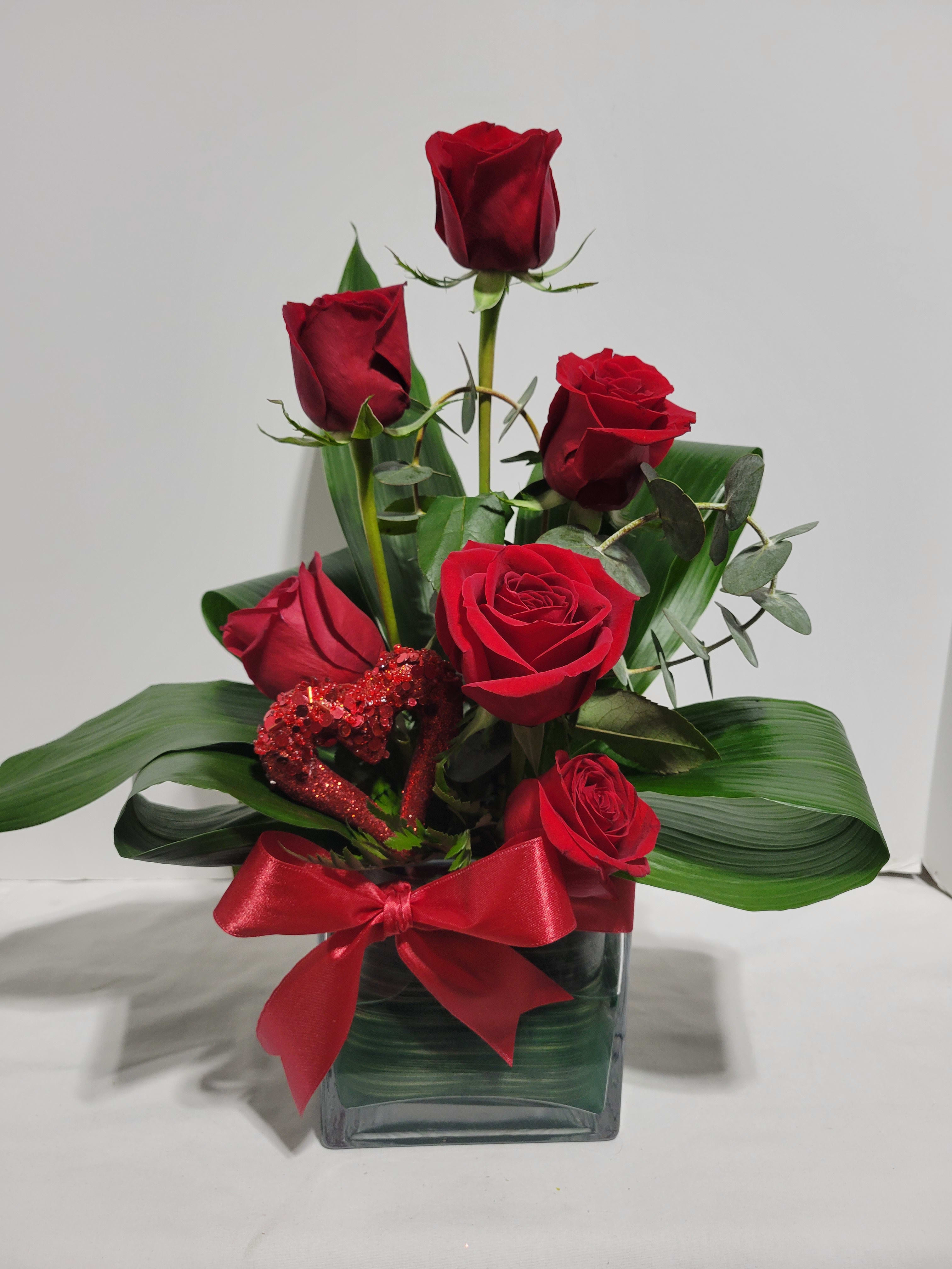 Red, Hot and Fabulous - Surprise her  with this contemporary spin on the traditional roses. Stunning  roses, gathered by FlowerBee floral artisans designed in a chic square glass vase and accented with a simple ribbon. Please specify rose color in special instructions. Standard Pricing - 6 Roses , Deluxe is 12 Roses