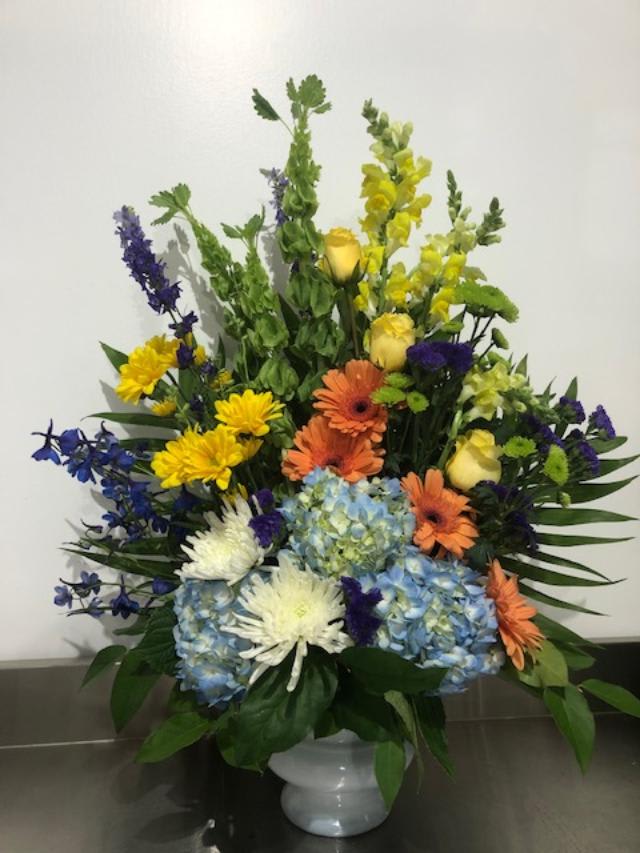 Colorful mixed flower arrangement in a white vase
