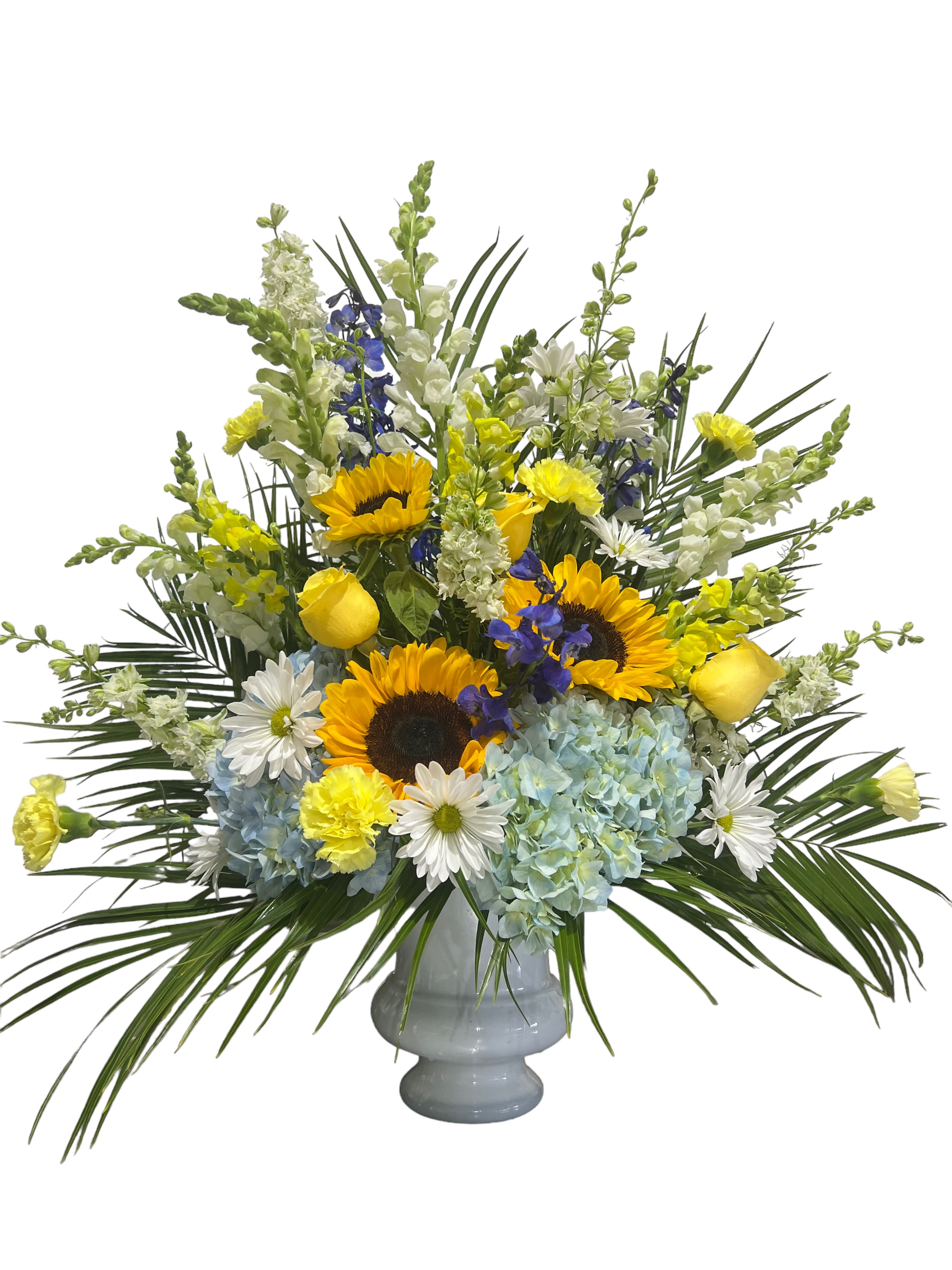Mixed bouquet of sunflowers, hydrangeas, and daisies in a gray vase