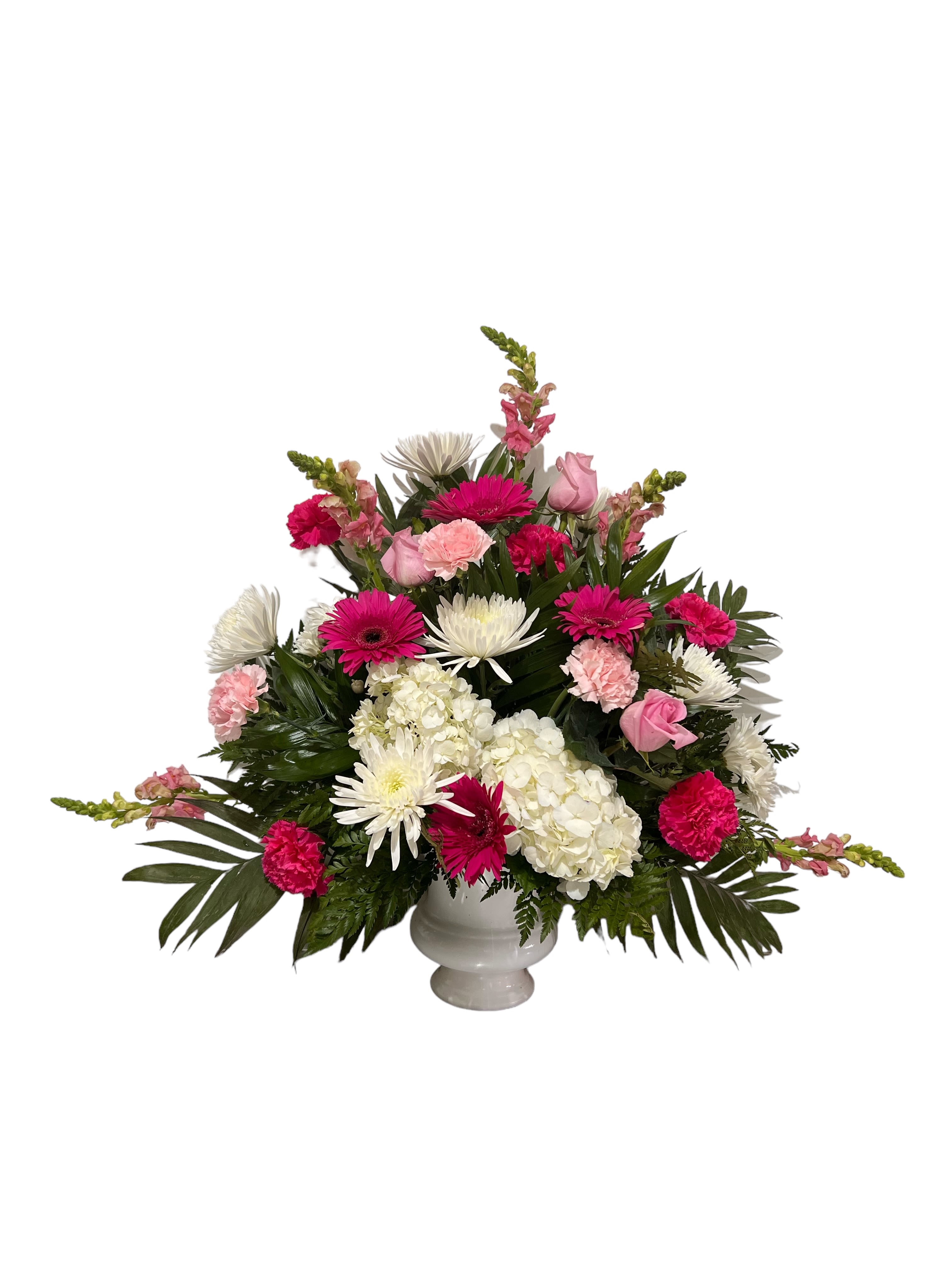 Pink and white mixed flower arrangement in a white urn vase